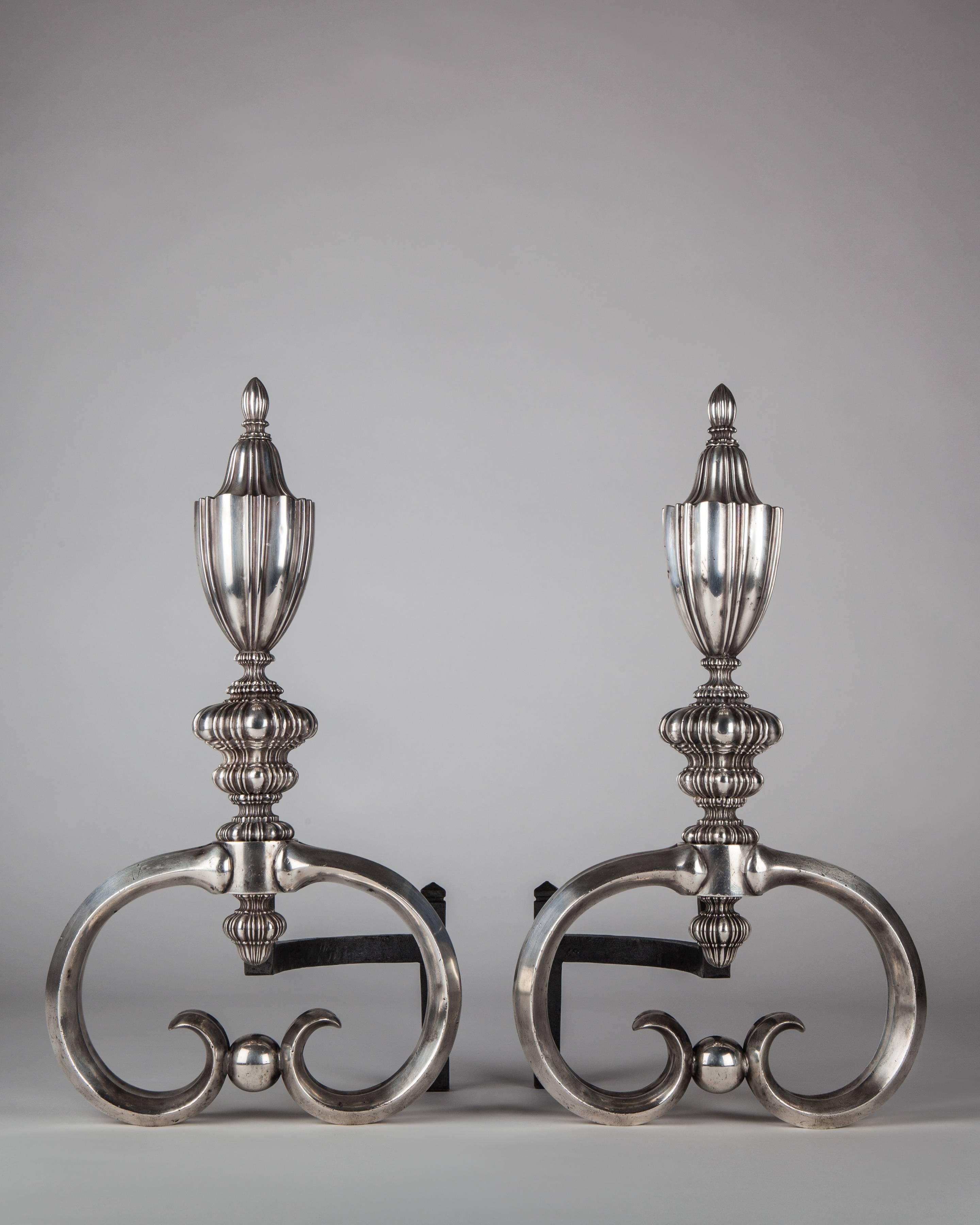 AFP0582
A pair of antique silver plate over bronze andirons or chenets with delicate linenfold urn-from bodies on bold, fluted, double C-scroll legs. Attributed to the New York maker E. F. Caldwell.
Dimensions:
Overall 20
