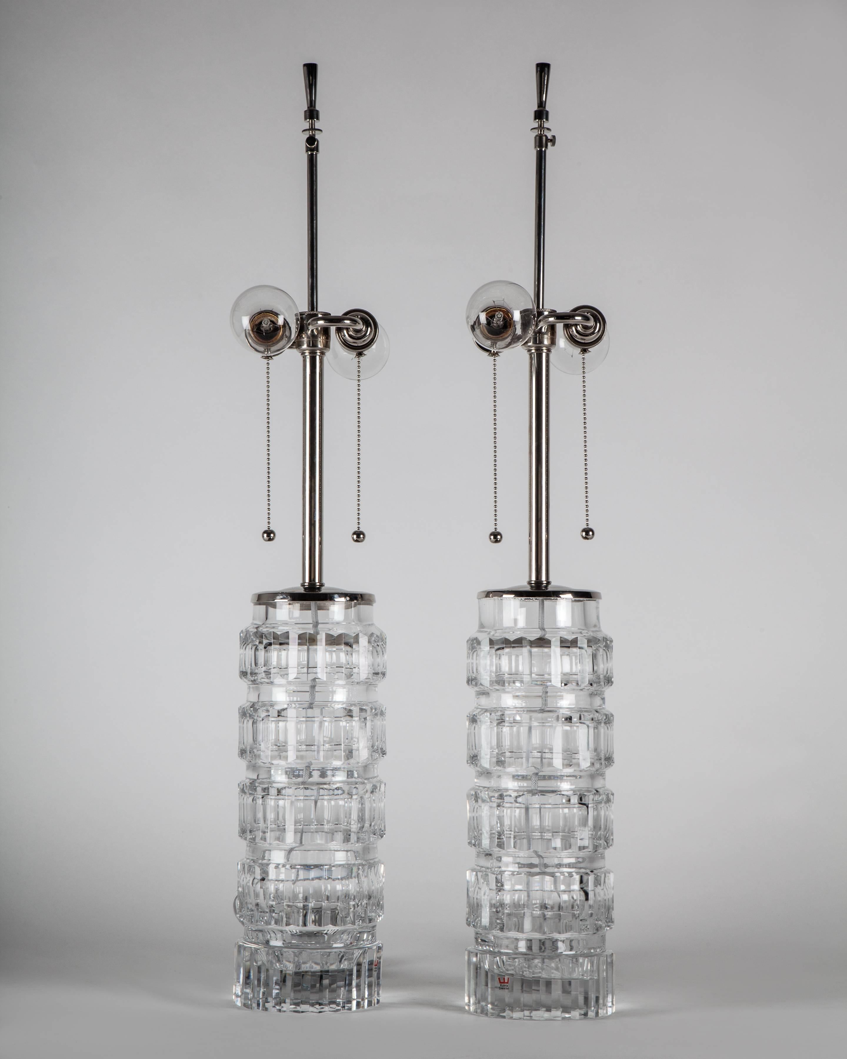 ATL1960
A pair of clear blown glass lamps with faceted cut patterns having polished nickel fittings. Signed by Ove Sandeberg for the Swedish glassmaker Kosta. Due to the antique nature of this fixture, there may be some nicks or imperfections in the