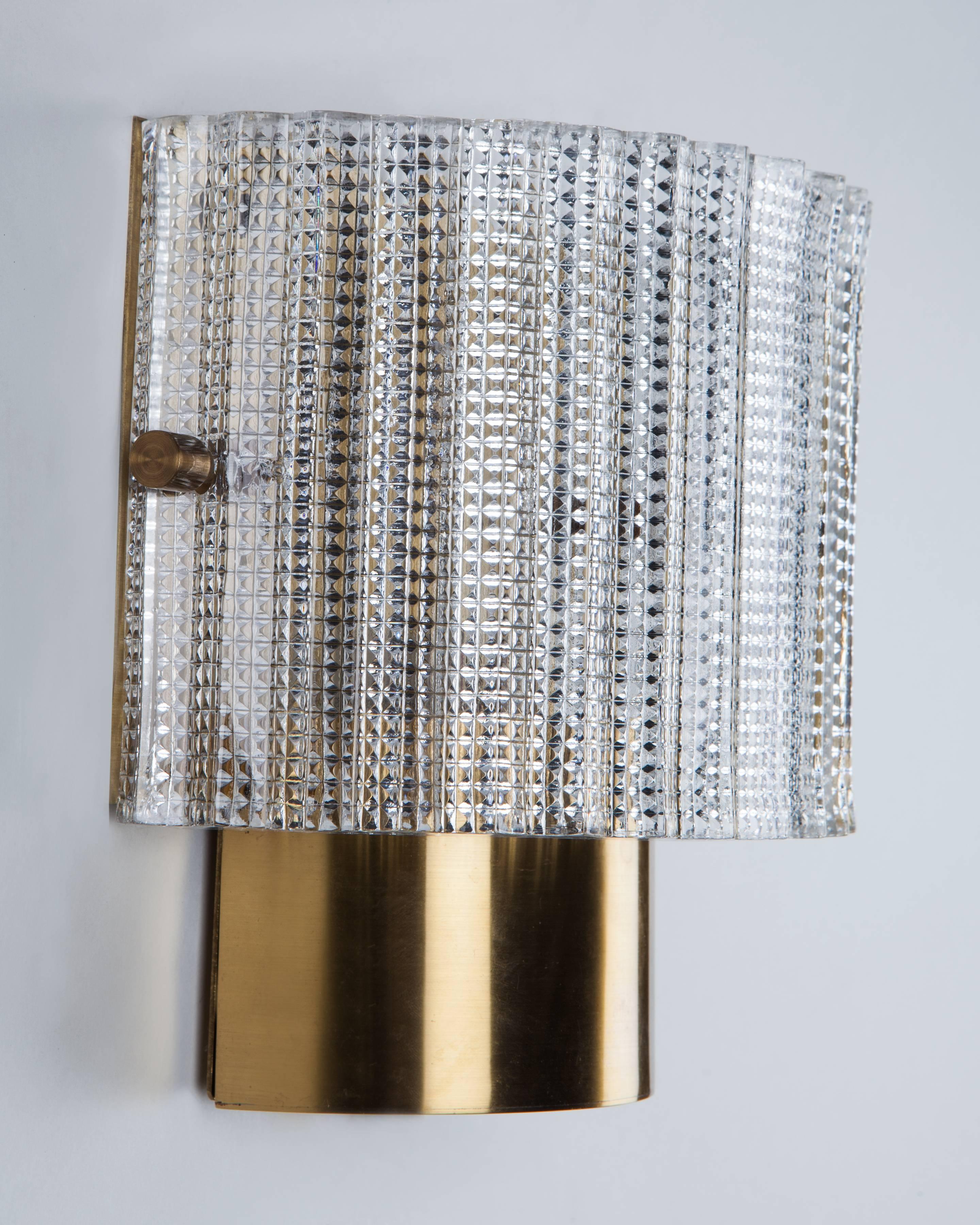 AIS3025
A pair of semi-cylindrical textured glass wall lights on aged lacquered brass frames. Signed by the Swedish glassmaker Orrefors. Due to the antique nature of this fixture, there may be some nicks or imperfections in the