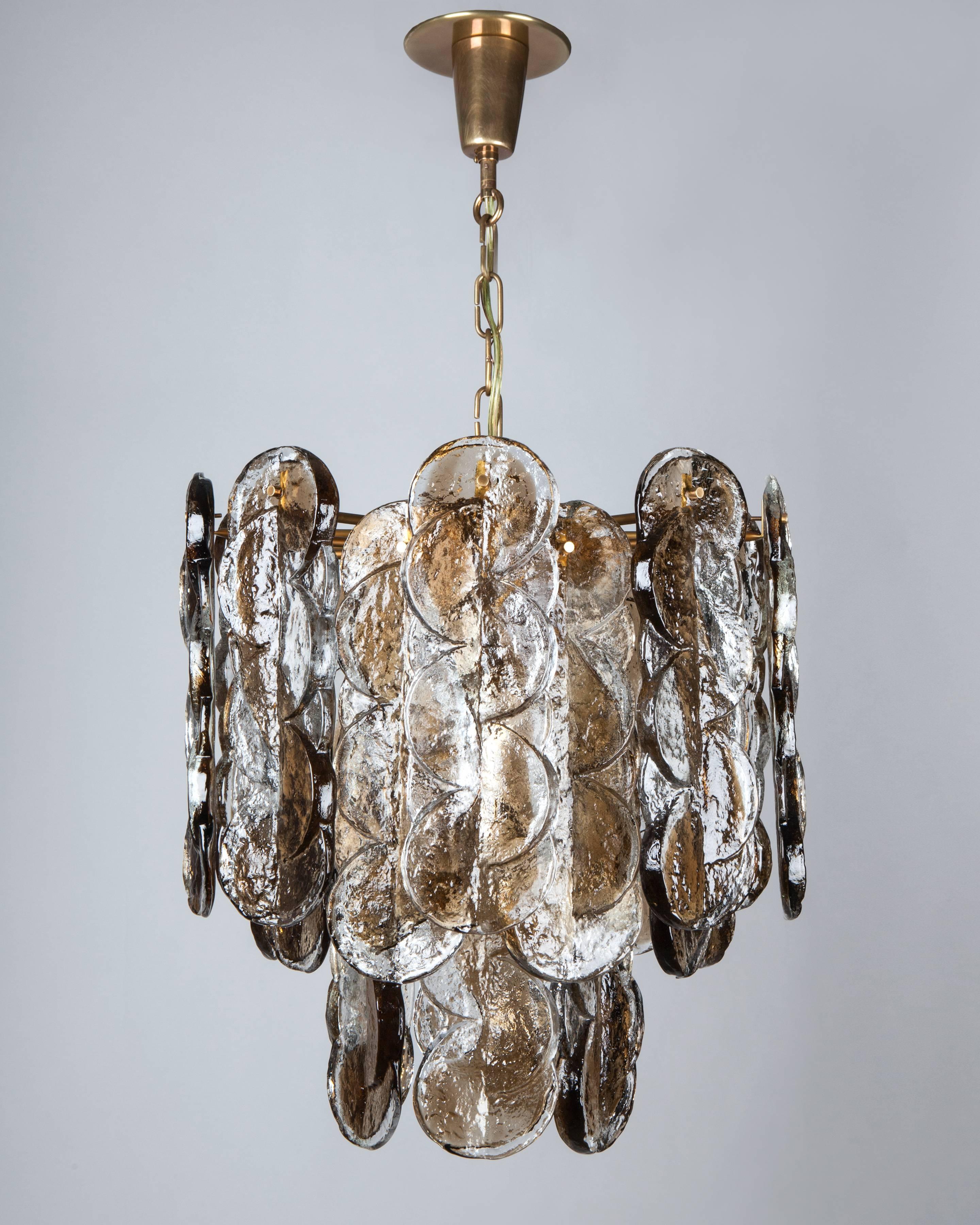 AHL4098
A vintage smoke and clear textured glass chandelier suspended from a frame in an age-darkened lacquered brass finish. Signed by the Austrian glassmaker Kalmar.

Due to the antique nature of this fixture, there may be some nicks or