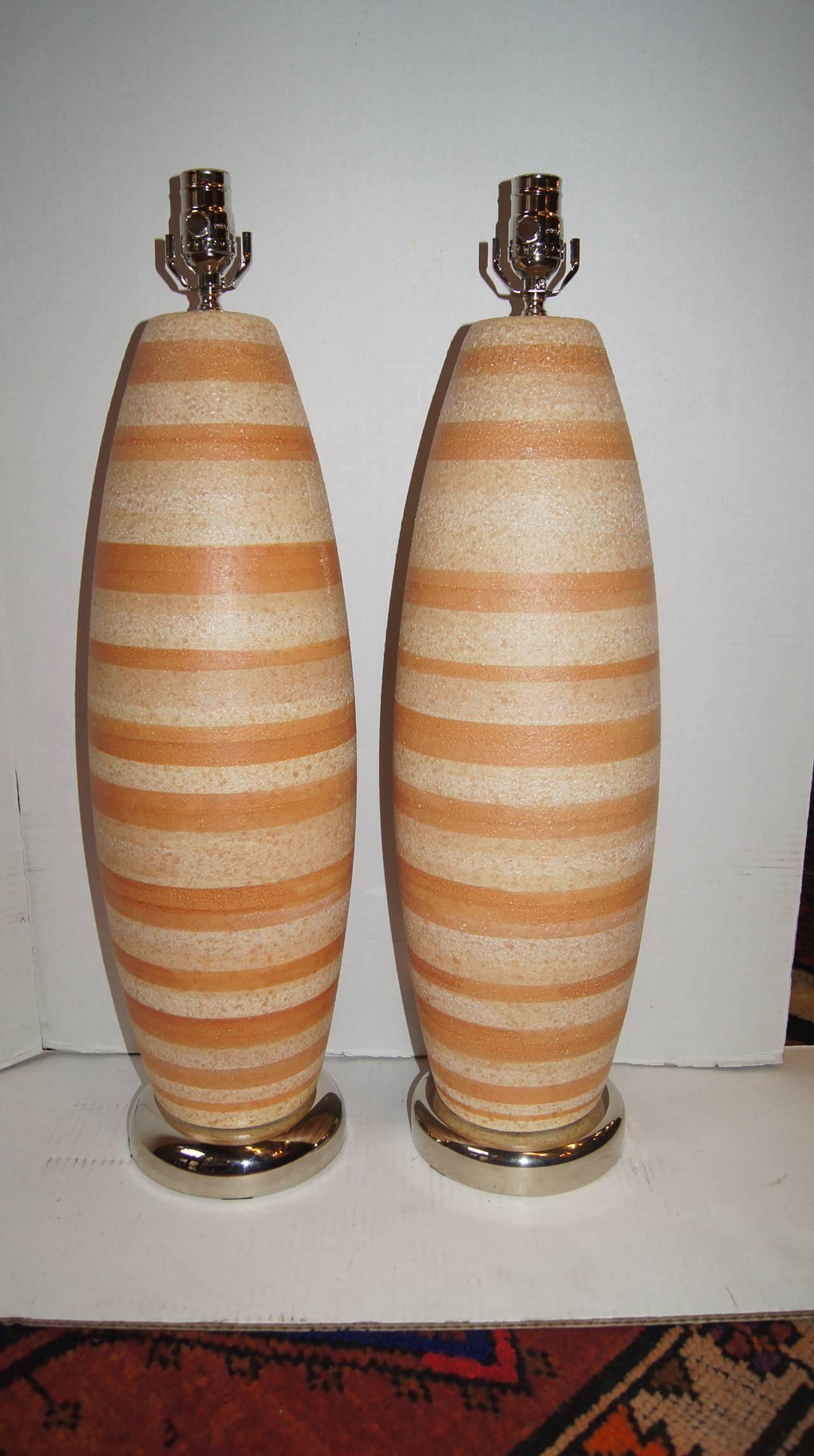 Pair of 1950s Italian ceramic lamps with two-toned striped body and nickel-plated bases.

Measurements:
Height of body: 23