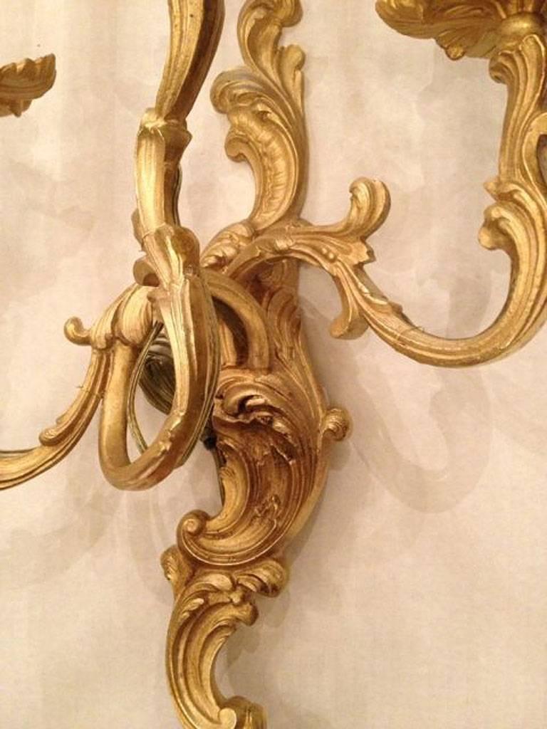 French gilt-bronze three-light sconces with scrolling and foliage motif on the body. 
Louis XV style. 

Measures: 21