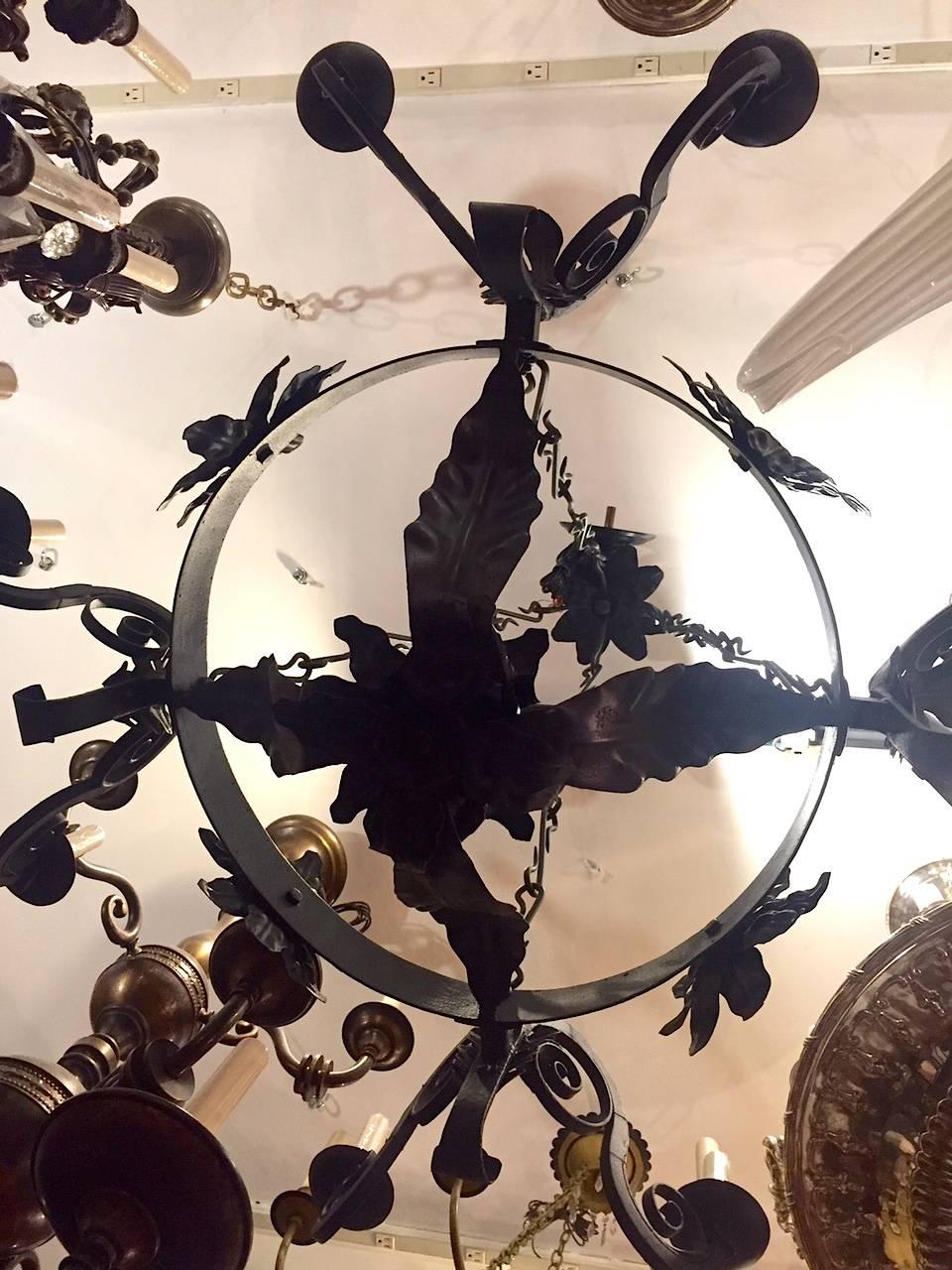 Wrought iron eight lights chandelier, scrolling motif on arms and hook chain, circa 1930s.

Measurements:
Height: 40