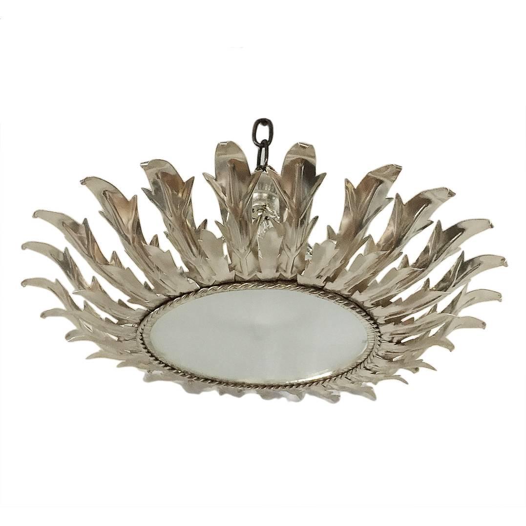 A circa 1940s Italian silver-plated sunburst light fixture with frosted glass inset and interior lights.

Measurements:
Diameter 25