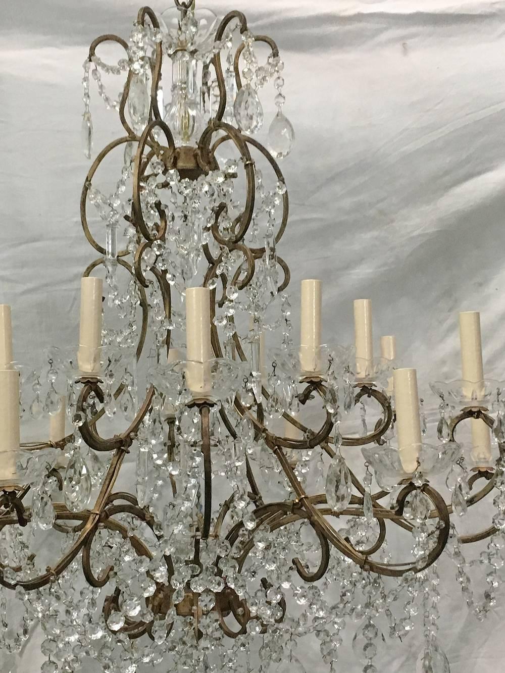 A large Italian, circa 1920s gilt metal and crystals chandelier with 18 lights. Original patina.

Measurements:
Diameter 34