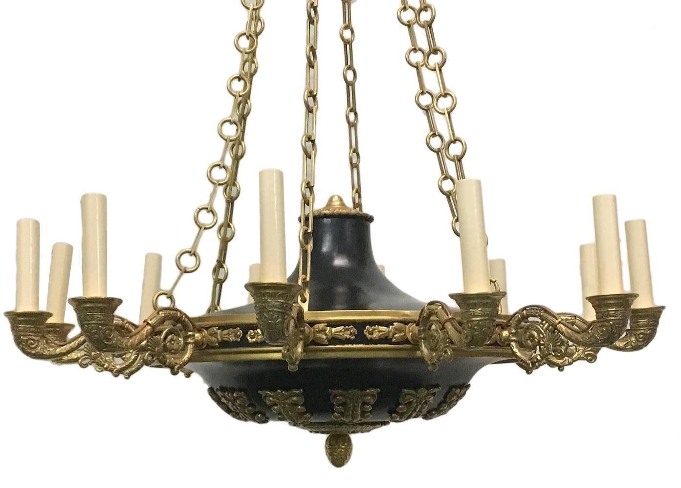 A twelve -arm French Empire-style gilt bronze and tole chandelier with foliage motif, circa 1940s.

Measurements:
Diameter 31