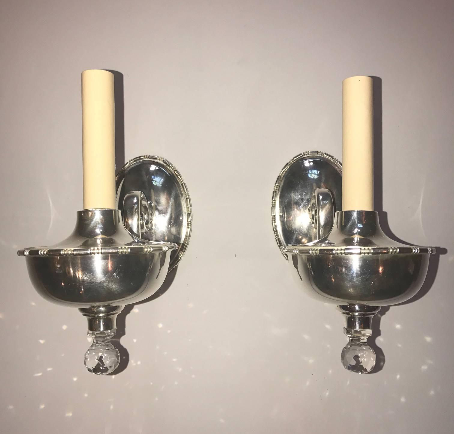 Set of four English silver plated single light sconces with crystal finial.