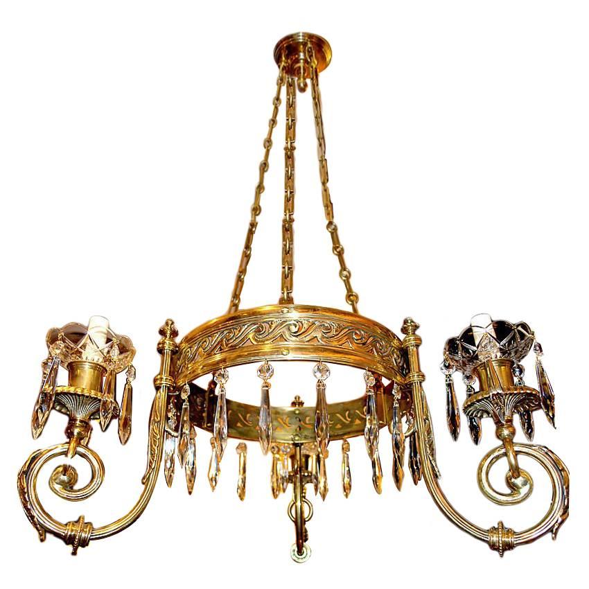 A pair of French, circa 1940s gilt bronze three-arm chandeliers with an open centre and crystal drops.

Measurements:
22