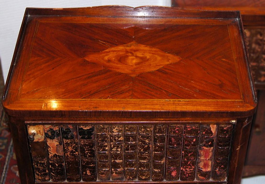 A single 1920s French side table with mahogany veneer and leather-bound book spines on the front top compartment door.
Measurements:
Height: 29