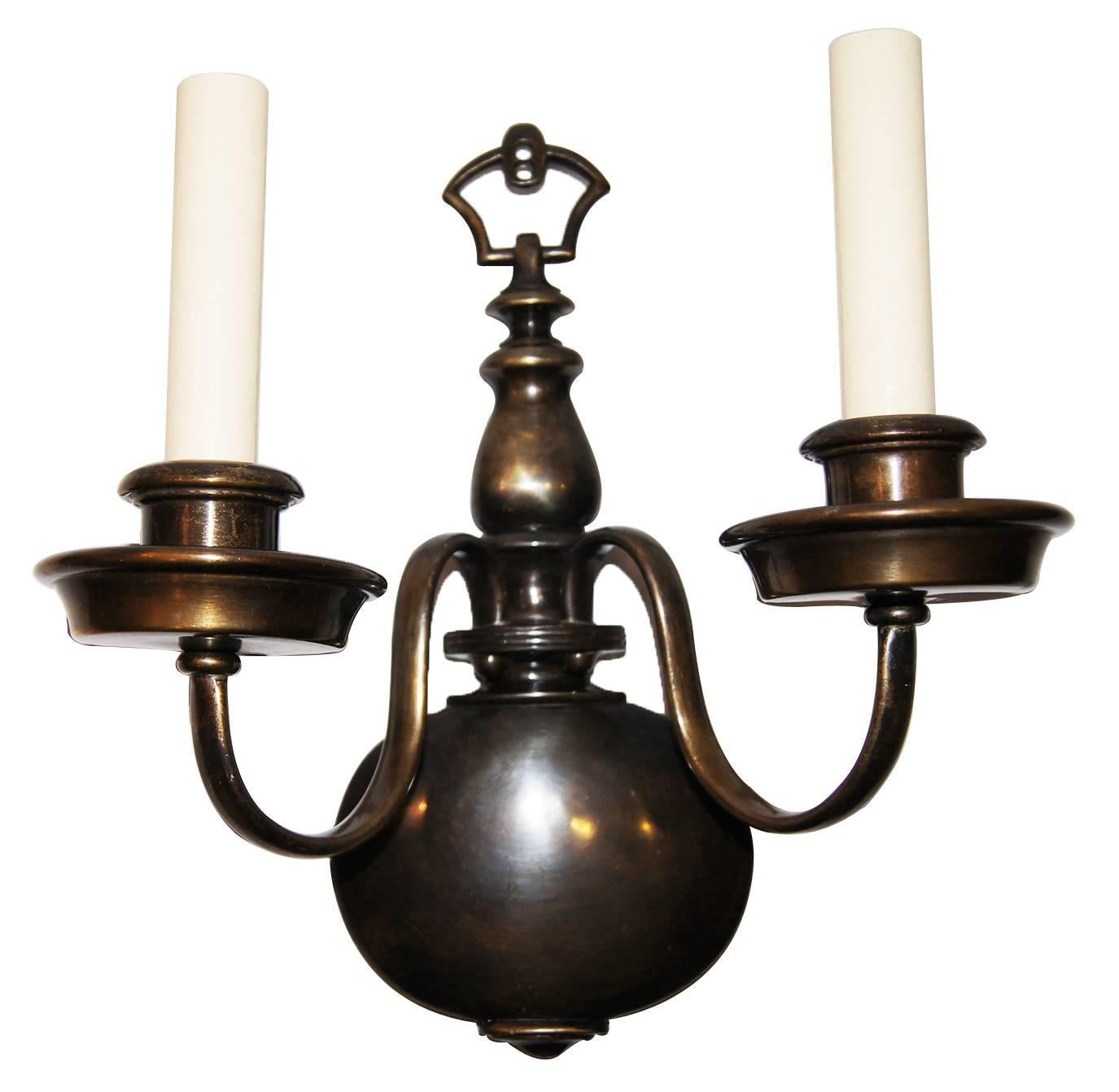 Set of four patinated bronze double light bronze sconces, Dutch style with original patina.