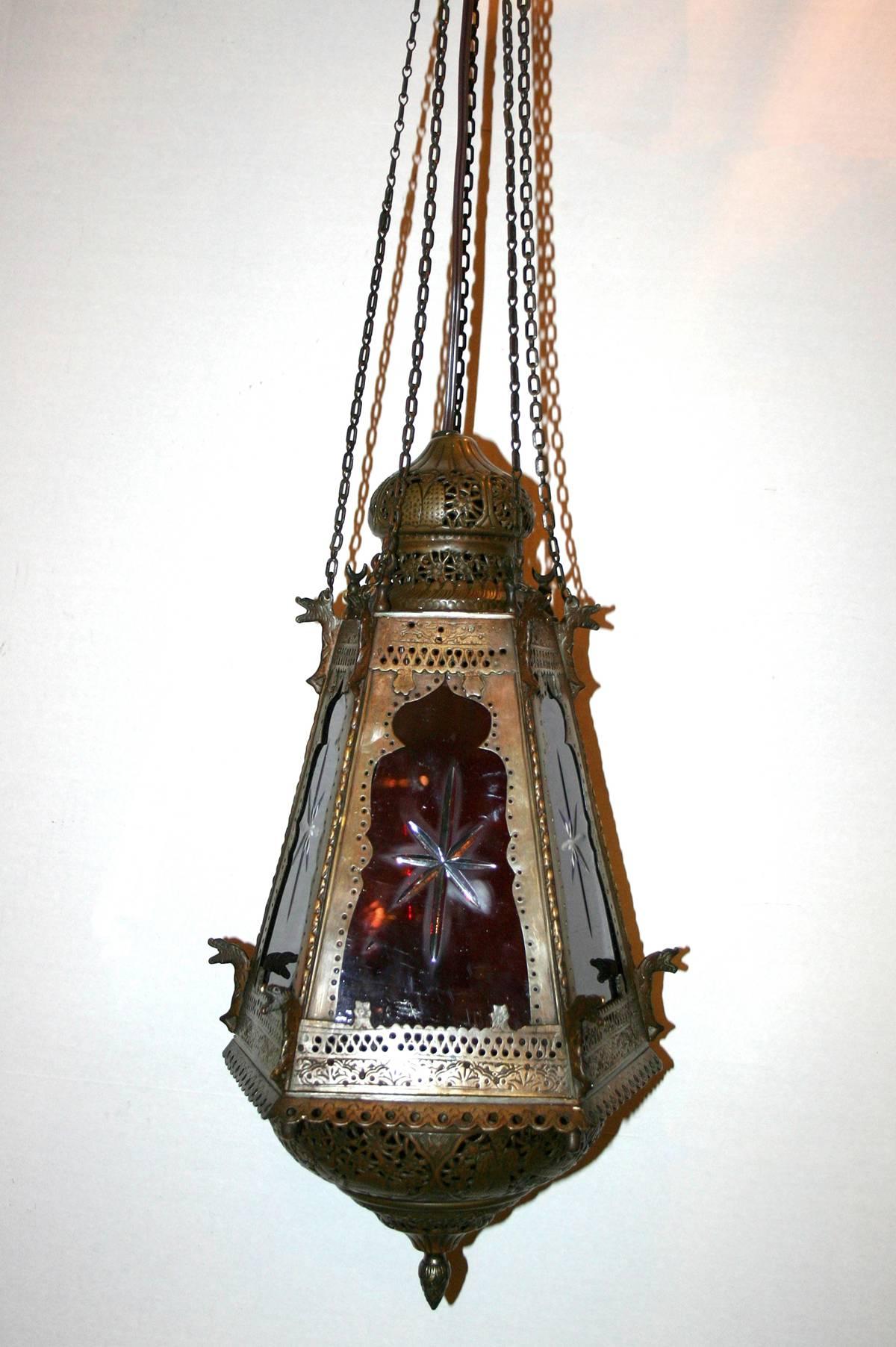 A circa 1900 Turkish pierced patinated brass lantern with original etched glass insets in red, blue and green colors. Interior light.
 Measurements:
Height: 35″ (adj.) drop
Diameter: 10″