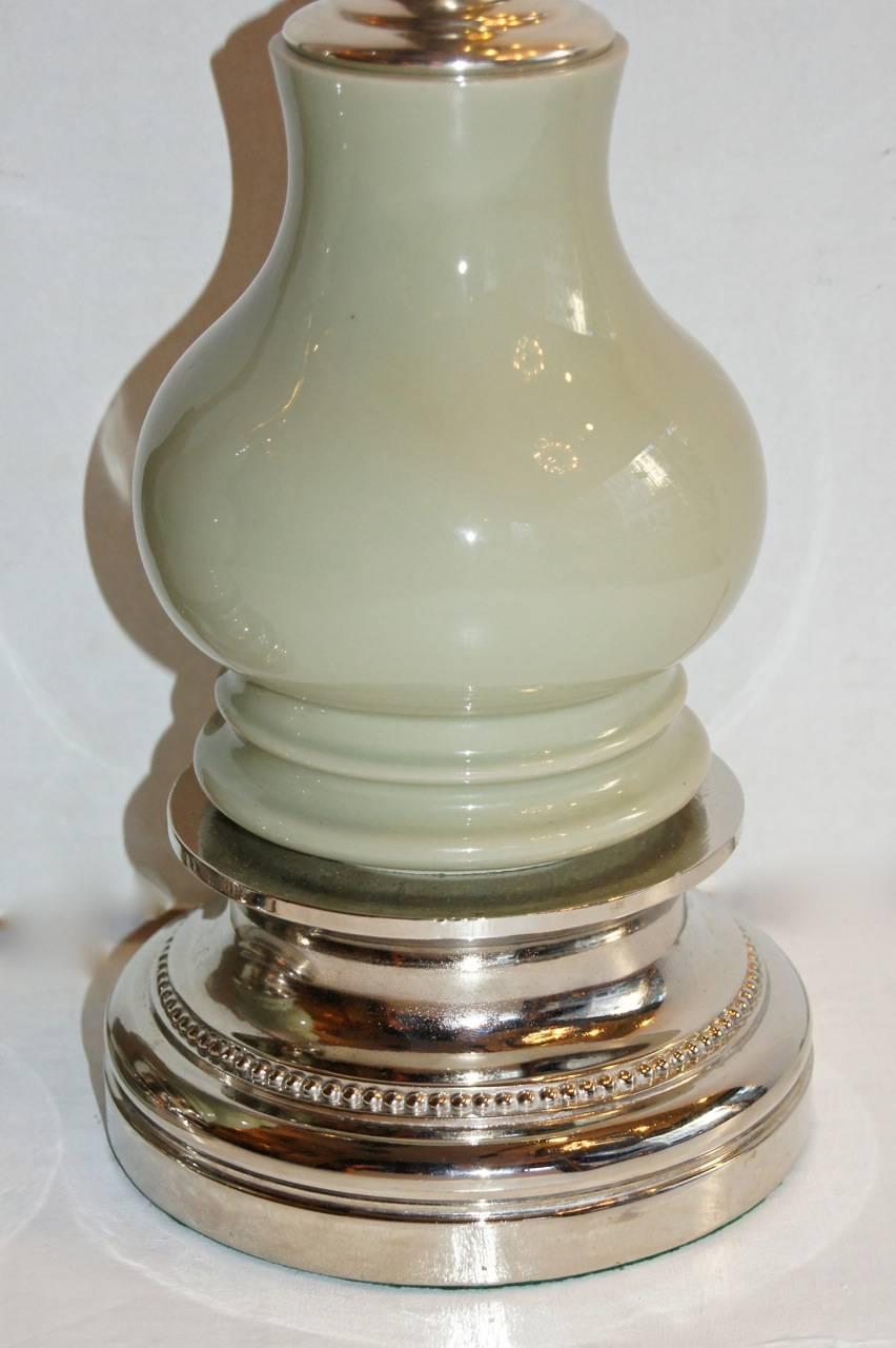 Une paire de lampes de table françaises en porcelaine émaillée céladon, plaquée argent, datant des années 1940.

Mesures :
Hauteur du corps : 20″.
Hauteur au repos de l'abat-jour : 28.5″.