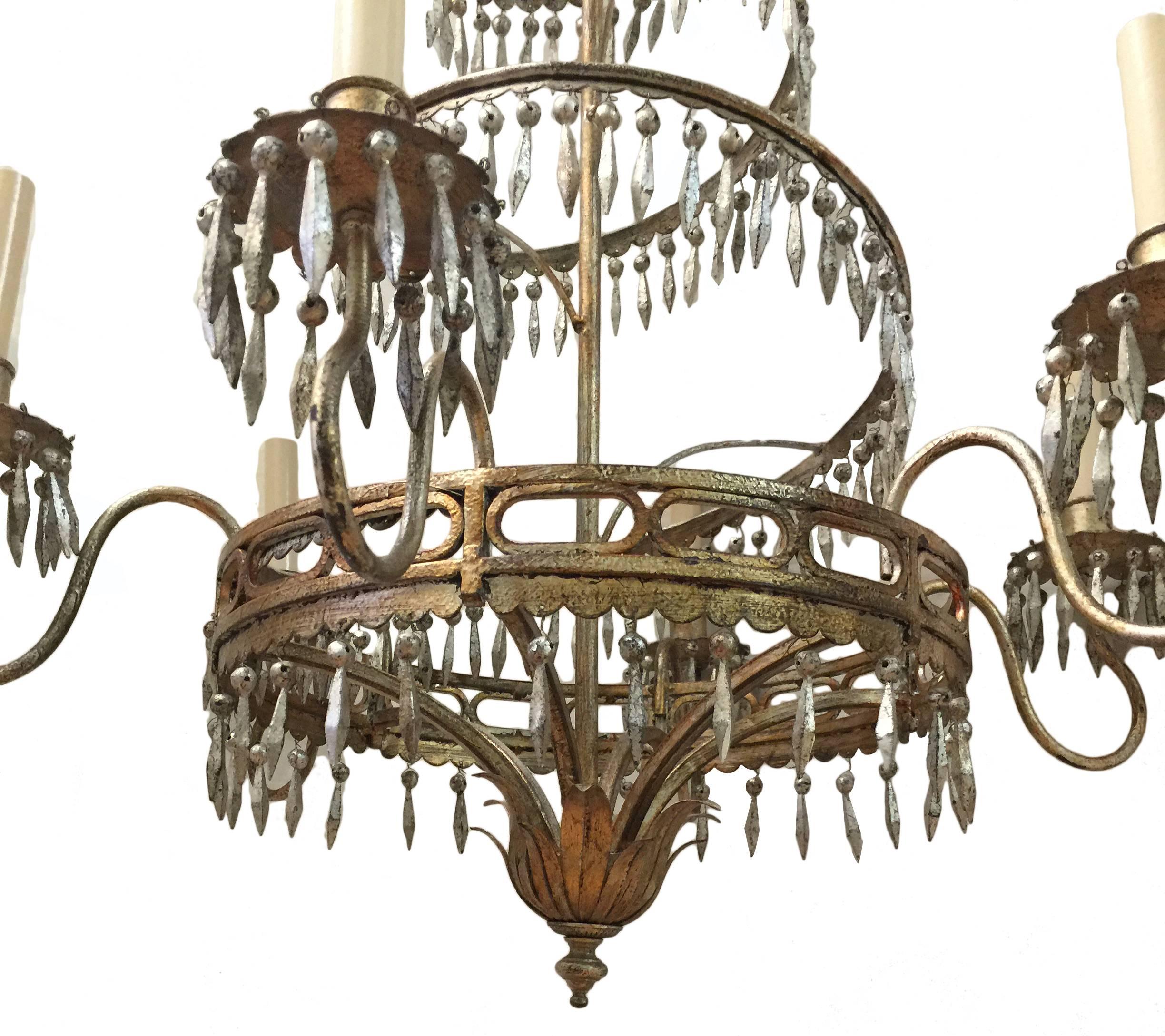 An Italian circa 1950s silver plated chandelier with 6 lights, patinated finish. The body with metal pendants.

Measurements:
Drop: 40