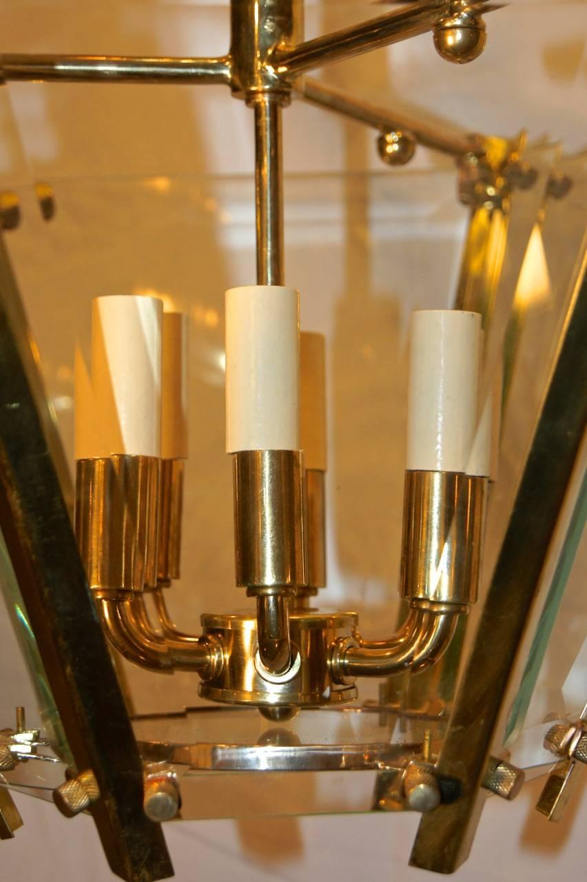 A set of nine circa 1960s Italian lacquered brass and beveled glass and pendant light fixtures with interior cluster of six lights. Sold individually.

Measurements:
Drop (height) 16