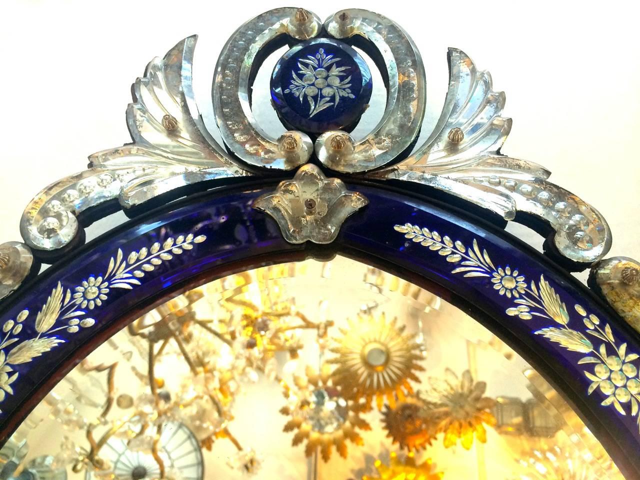A Venetian circa 1930's etched mirror with cobalt blue mirrored frame

Measurements:
Height: 28