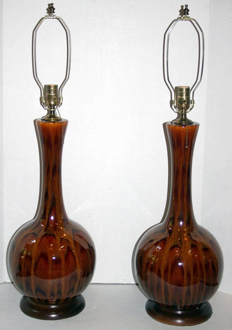 A pair of large circa 1950's Italian glazed porcelain table lamps with wooden bases.

Measurements:
Height of body: 23