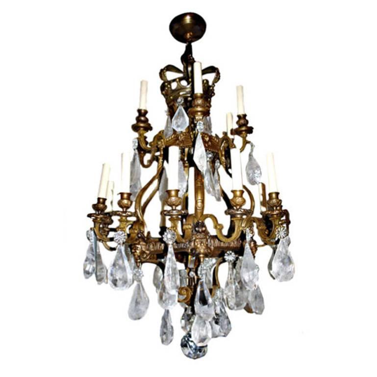 A French, circa 1900 patinated bronze chandelier with very good casting work depicting grotesque figures. With large pendant rock crystal. Original patina.
18 lights.