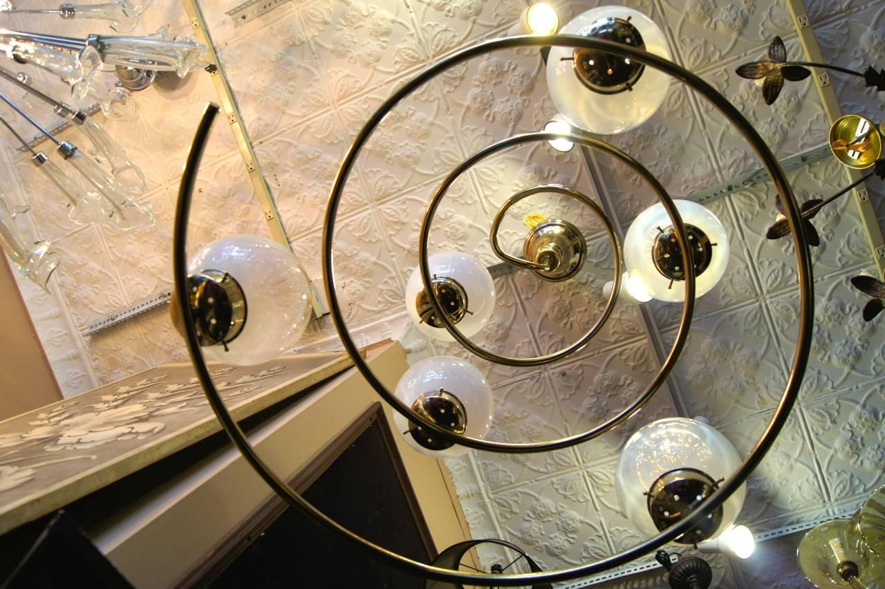 A Italian spiral light fixture in polished bronze and with art glass globes, circa 1960s.
 
Measurements:
Height (current drop) 46