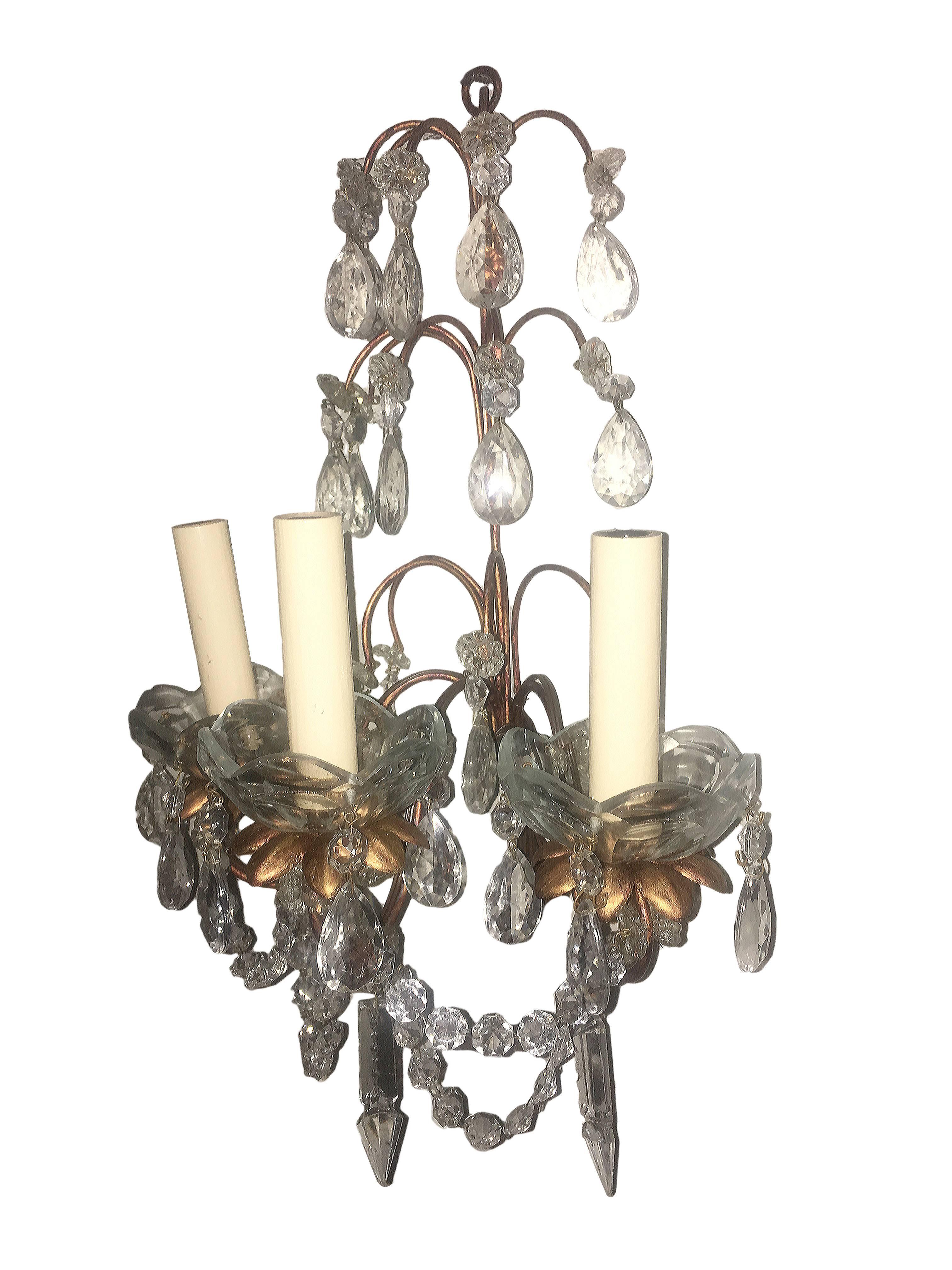 Set of eight gilt metal sconces with original patina, three lights each, with crystal drops and pendants.
Sold in pairs.
Price per item.

Measurements:
17" total height
12.5" wide
7" deep.