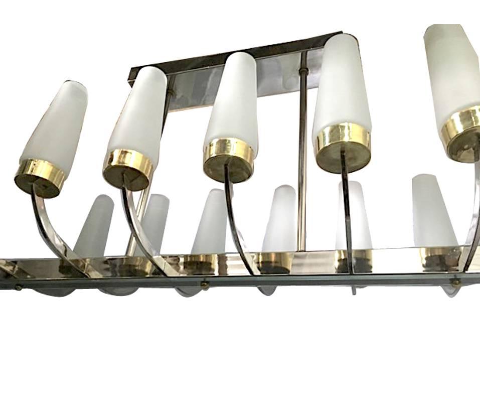 A French nickel-plated light fixture with gilt details and molded glass shades, circa 1960s. 12 lights.

Measurements:
66