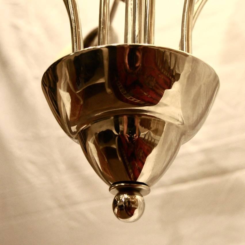 An Italian nine-arm circa 1960s moderne nickel-plated chandelier with Calla Lily shaped glass shades.

Measurements:
Height: (current drop): 55