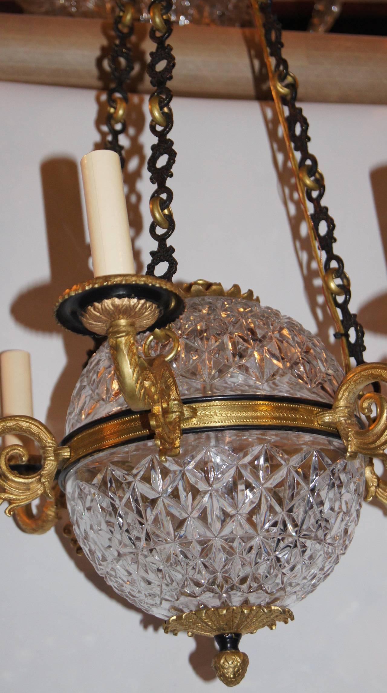 A French Empire-style six light chandelier with cut crystal body, gilt and painted finish.

Measurements:
Diameter: 20