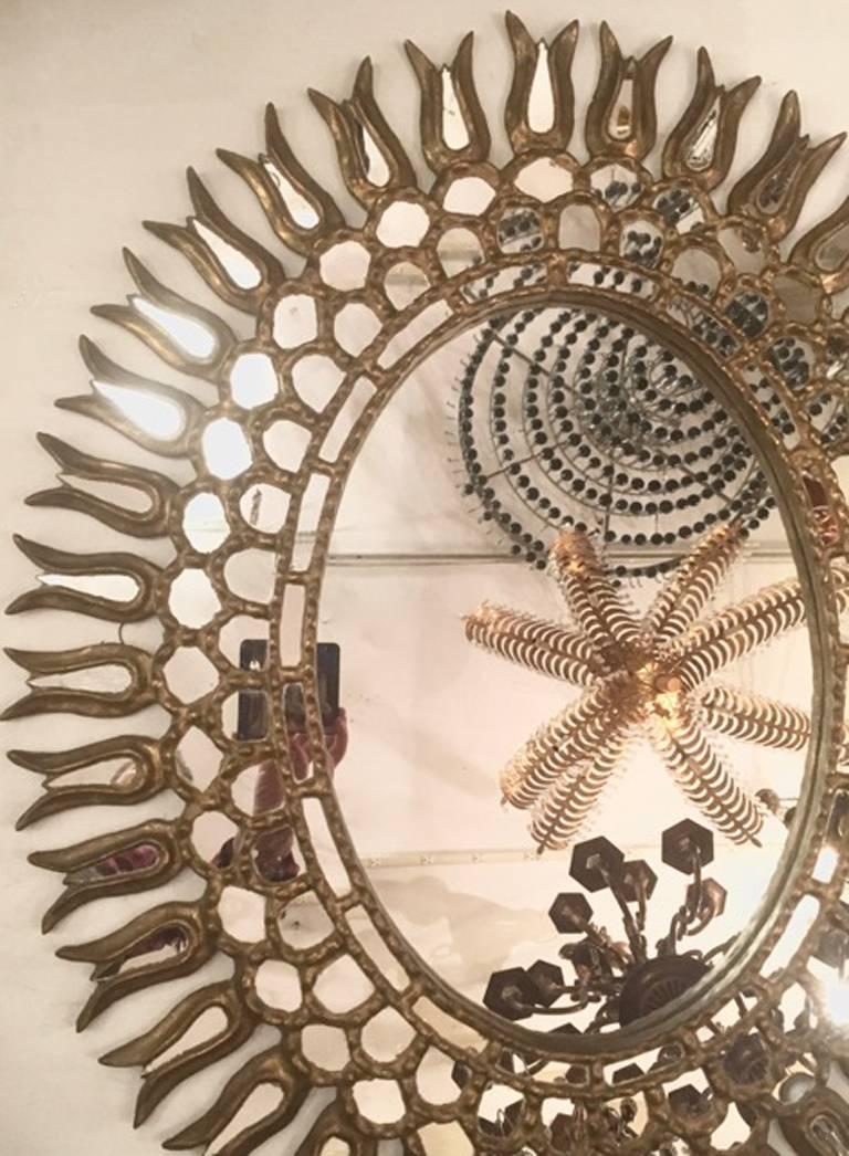 Miroir en bois sculpté et doré des années 1920 avec inserts en miroir, patine d'origine.

Mesures :
Hauteur 38