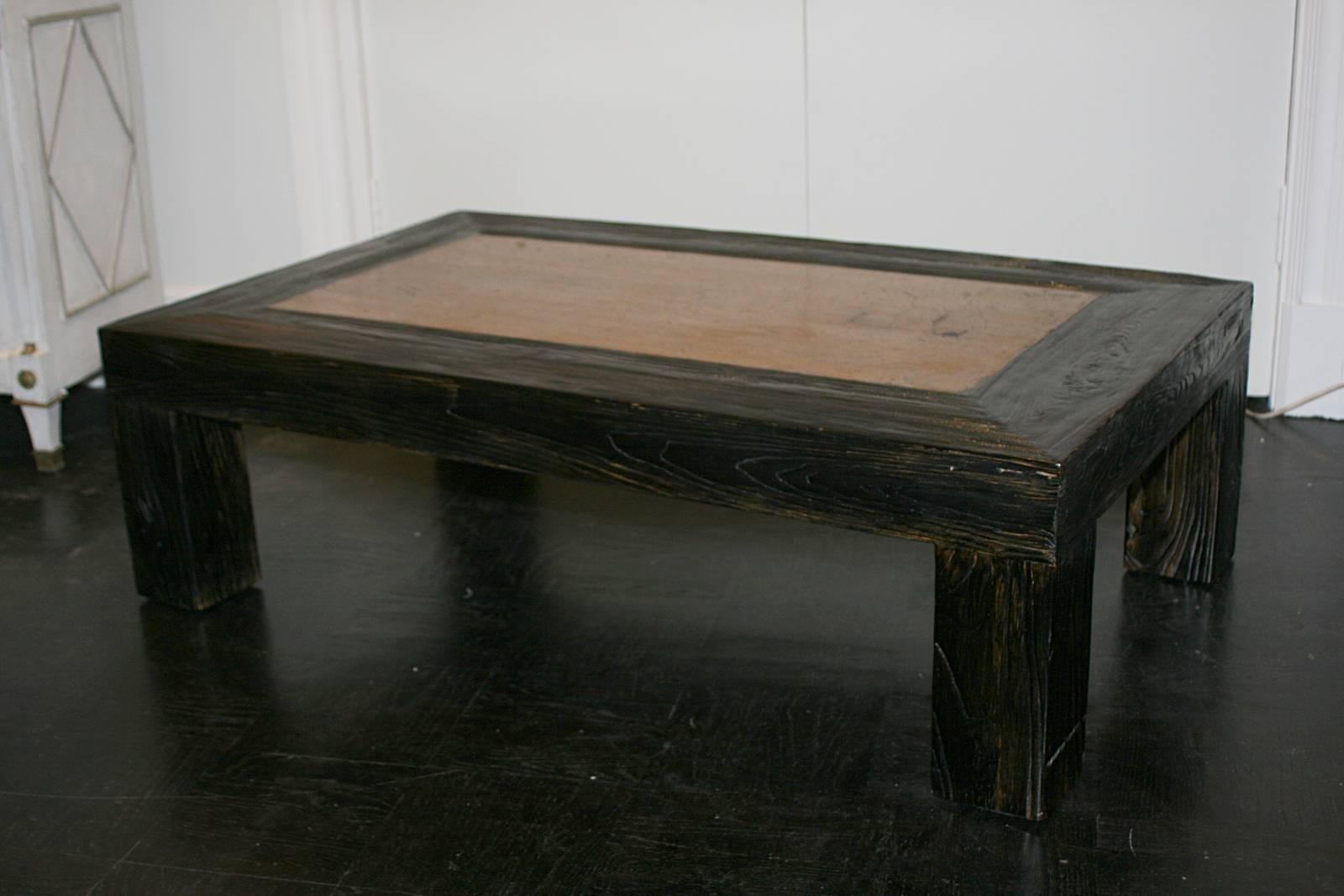 Early 20th century ebonized exotic wood cocktail table, grey stone rectangular inset, square block legs.