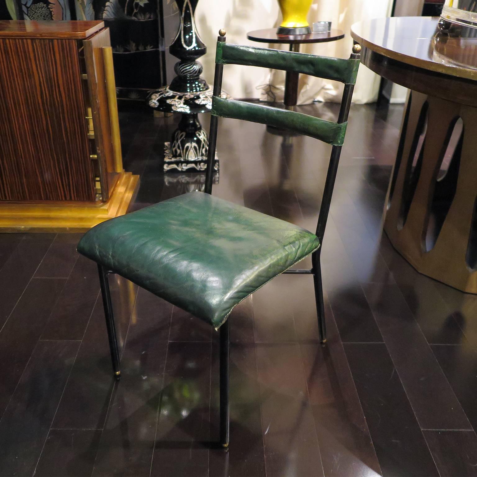 Pair of chairs by Jacques Adnet in original green leather. Iron frame with brass details. Original condition.