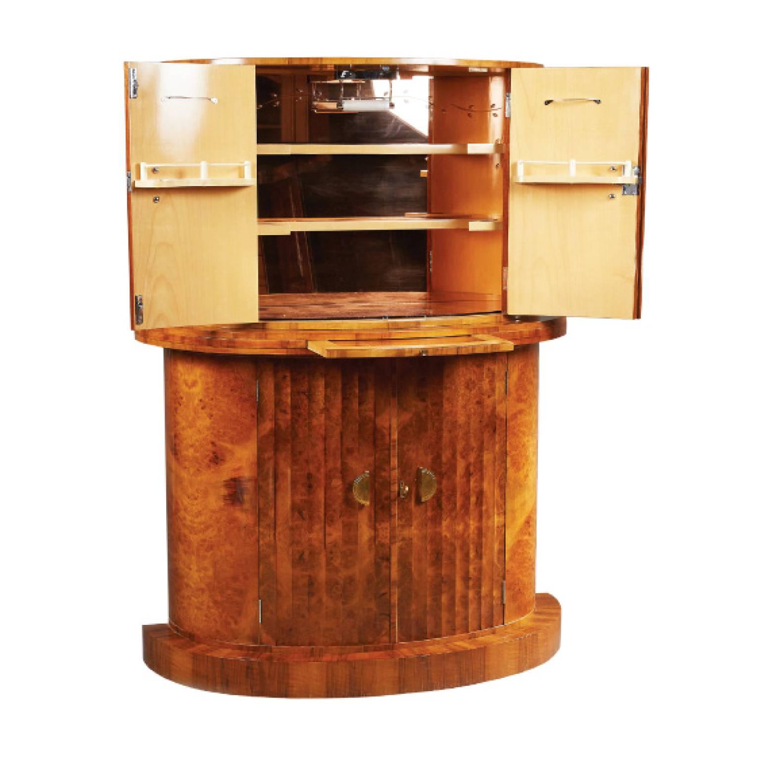 Beautiful tall demilune bar in elm burl veneer with fluted doors and original brass hardware. Top cabinet in citron wood opens to mirrored interior with subtle leaf decoration with light at top and shelving for glassware. Mixing plateau pulls out