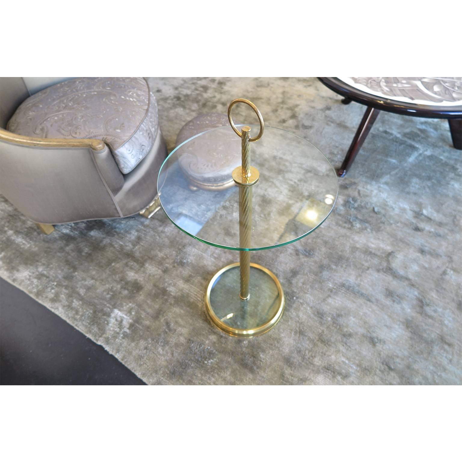 Pair of glass & brass round side tables from France c. 1940's -1950's.  Design by Hermes. Each table has a twisted brass stem with an over-sized ring on top.   