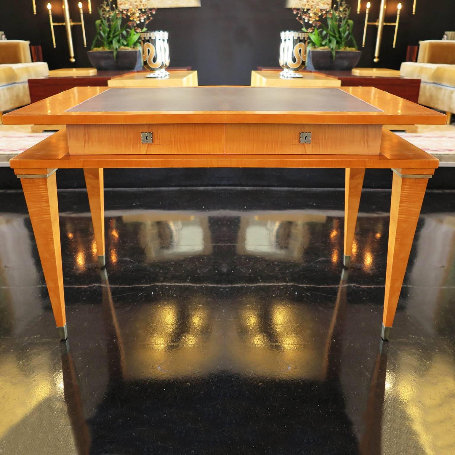 Großzügig bemessener Mid-Century Modern-Schreibtisch aus Kirschholz und Ahorn. Dieses elegante Möbelstück verfügt über eine zweistufige Platte mit zwei abschließbaren Schubladen und einer schwarzen Ledereinlage auf der Tischplatte. Ausgestattet mit