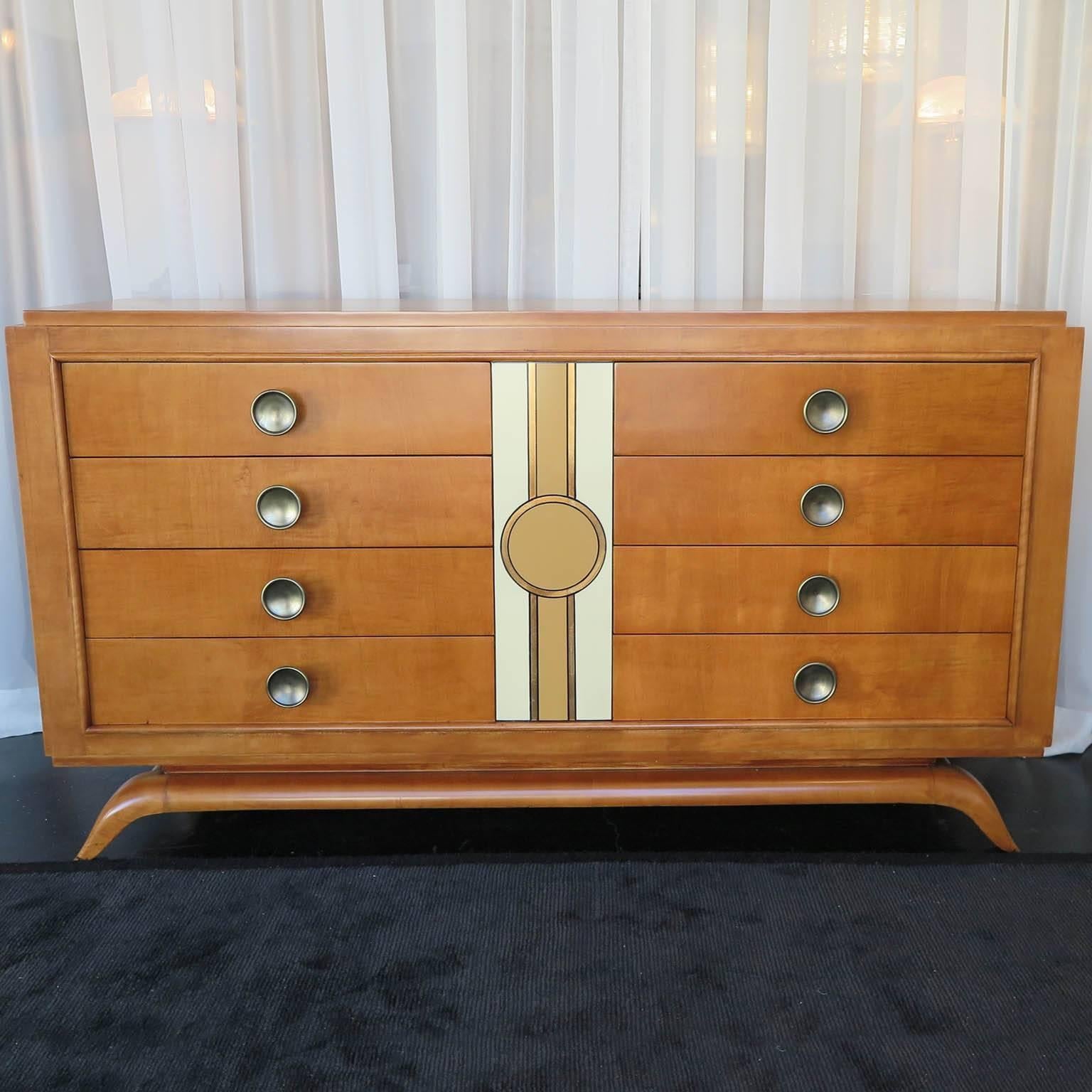 Mid-Century maple and cherrywood sideboard with matt finish. Original brass hardware on drawers with gold leaf and lacquer motif in center. This rich sideboard features eight generously sized drawers and it's streamline frame sits on a curved base