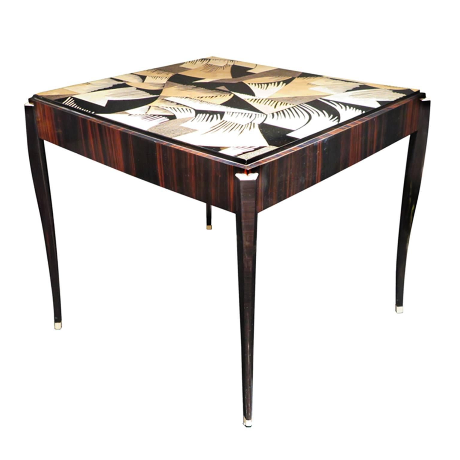 Stunning pair of Art Deco tables in Macassar ebony. Each tabletop features a unique geometric motif inlaid with eggshell with black lacquer details. Four delicate curving legs with ivory lacquered feet and corner details. This pair is ideal as game,