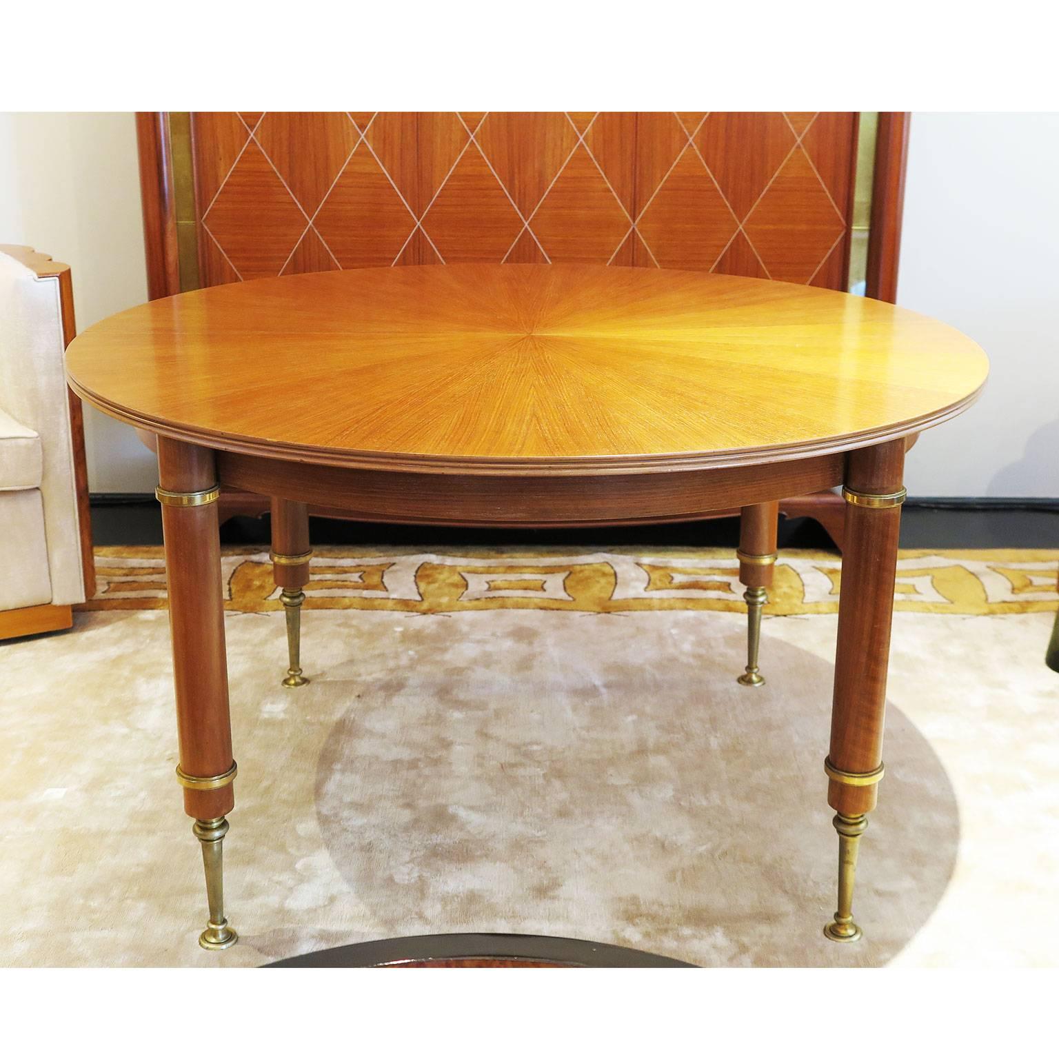 Signed by Jules Leleu and stamped Leleu, Paris, Made in France and numbered 31235. Dining or kitchen table in blond mahogany veneer top with starburst design and blond mahogany wood apron and legs. Brass cylinder legs and upper and lower legs