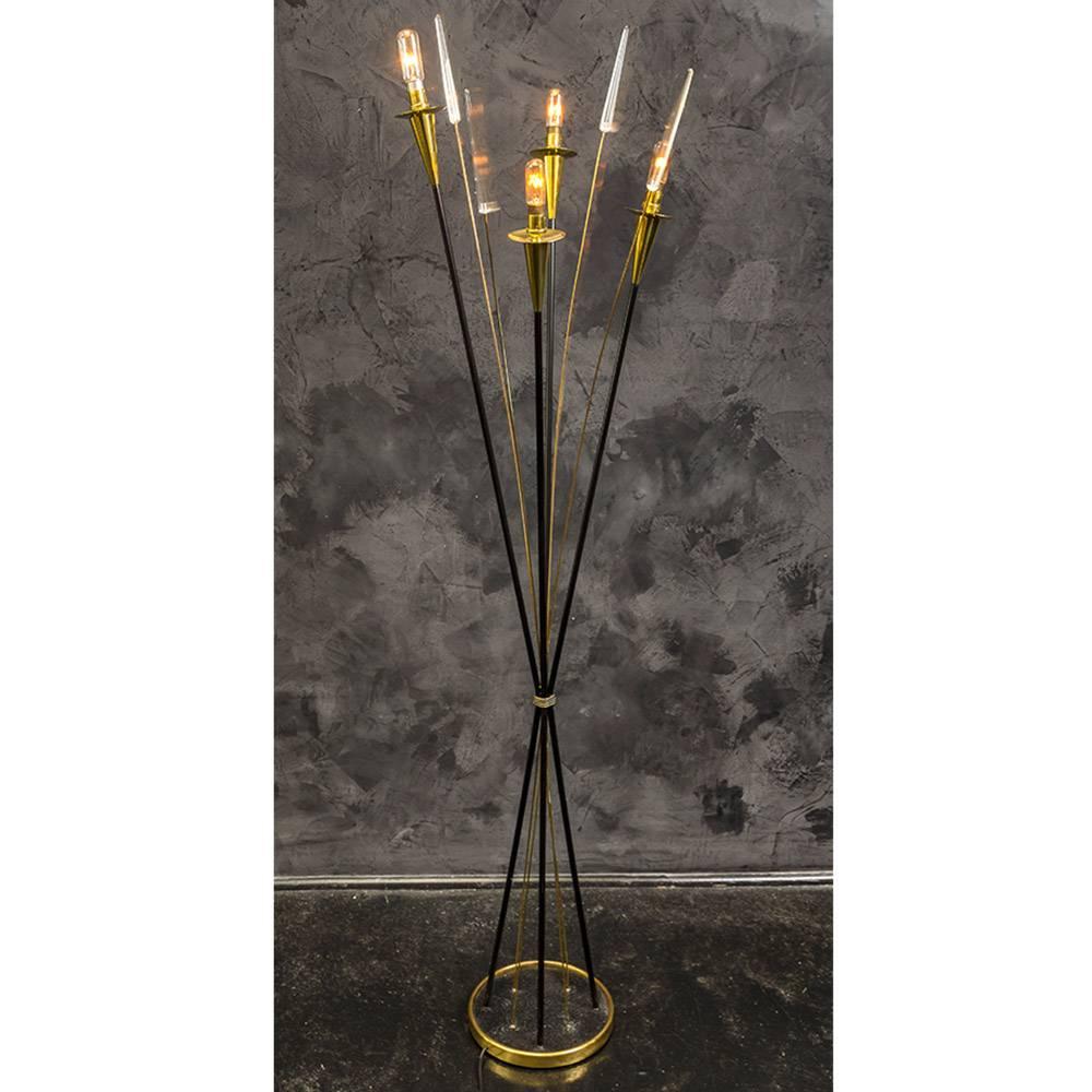 Midcentury floor lamp with four black metal arms with polished brass fittings and exposed bulbs. Four brass stems with Lucite arrows that flexibly swing back and forth, when touched. 
The eight stems meet in the center through a ribbed, antiqued