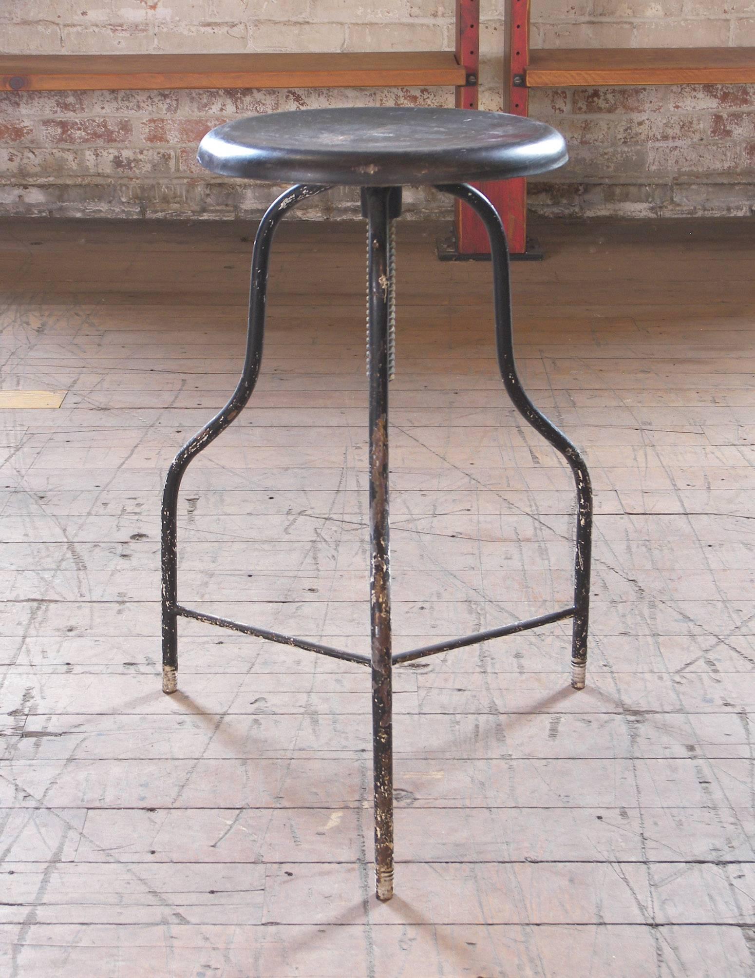 Vintage black metal medical stool with three legs, adjustable seat height. Seat diameter is. 12 1/4″.
 