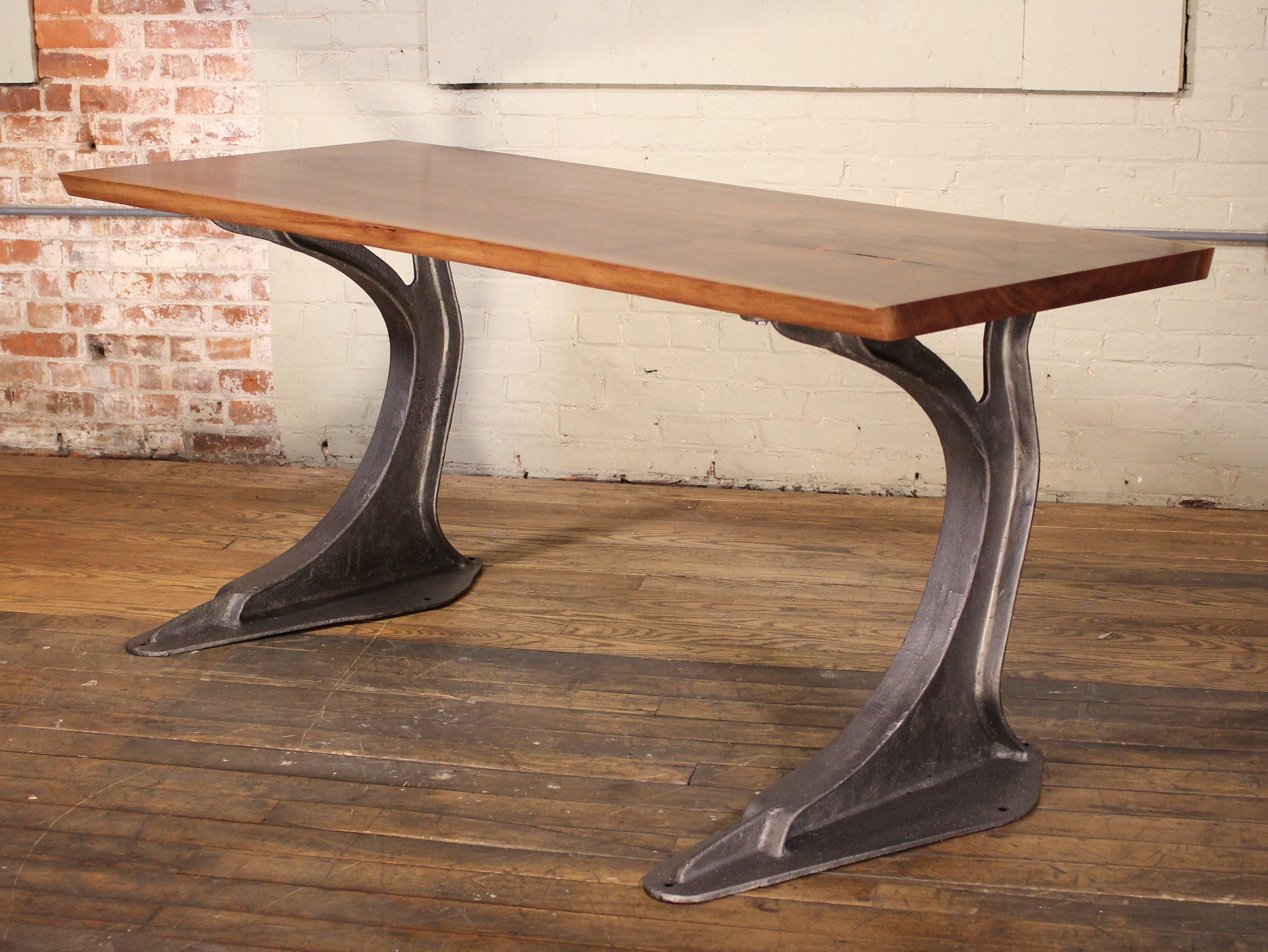 Live edge free-form desk made from English elm with butterfly ties atop two vintage cast iron machine legs from a factory commercial press. Top measures 71 3/4