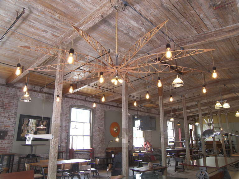 Chandelier constructed from ten wooden airplane trusses with eighteen Edison light bulbs including a three bulb cluster in the center. Diameter is 96