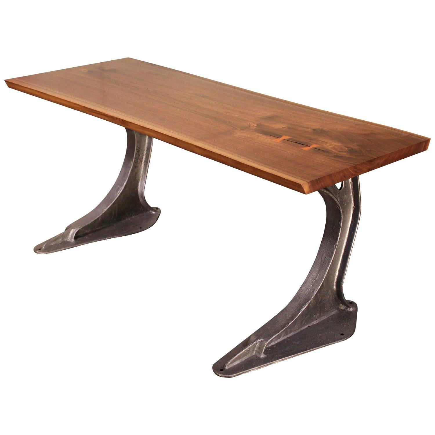 Live edge free-form desk made from English elm with butterfly ties atop two vintage cast iron machine legs from a factory commercial press. Top measures 71 3/4