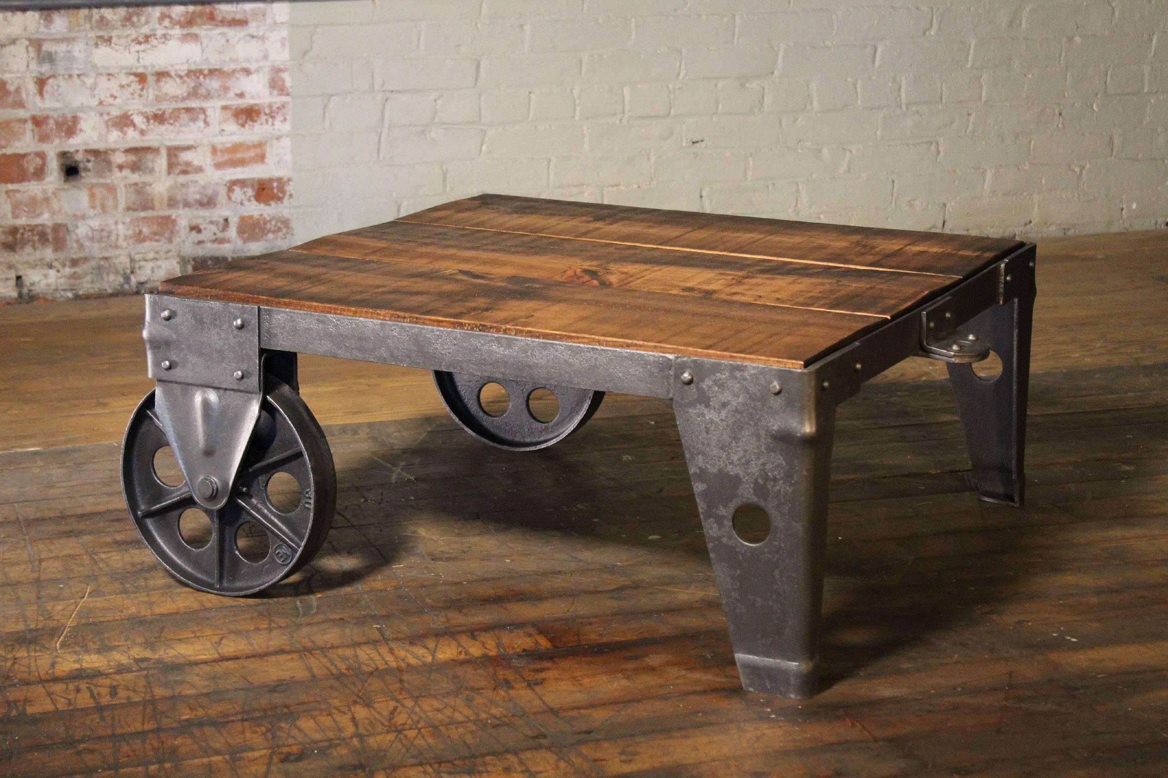 Authentique et originale table basse ou chariot industriel moderne vintage, fabriqué en pin brut, acier, métal et fonte. Le dessus en bois mesure 32