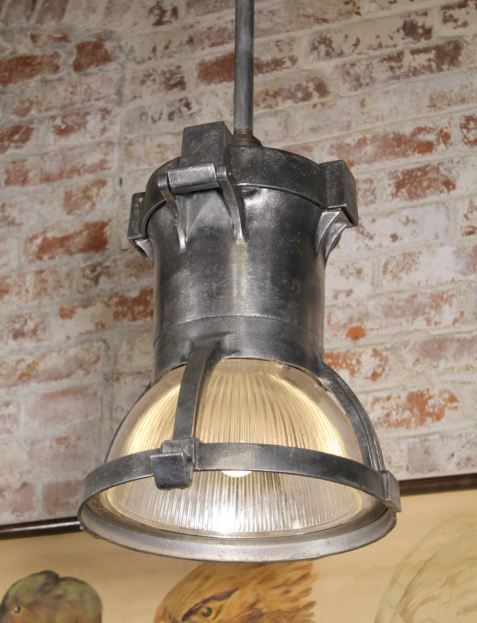 Authentic American 1940s cast iron and ribbed glass overhead pendant light, ceiling lamp, overhead light. Glass appears to be by Holophane. Glass diameter measures 10