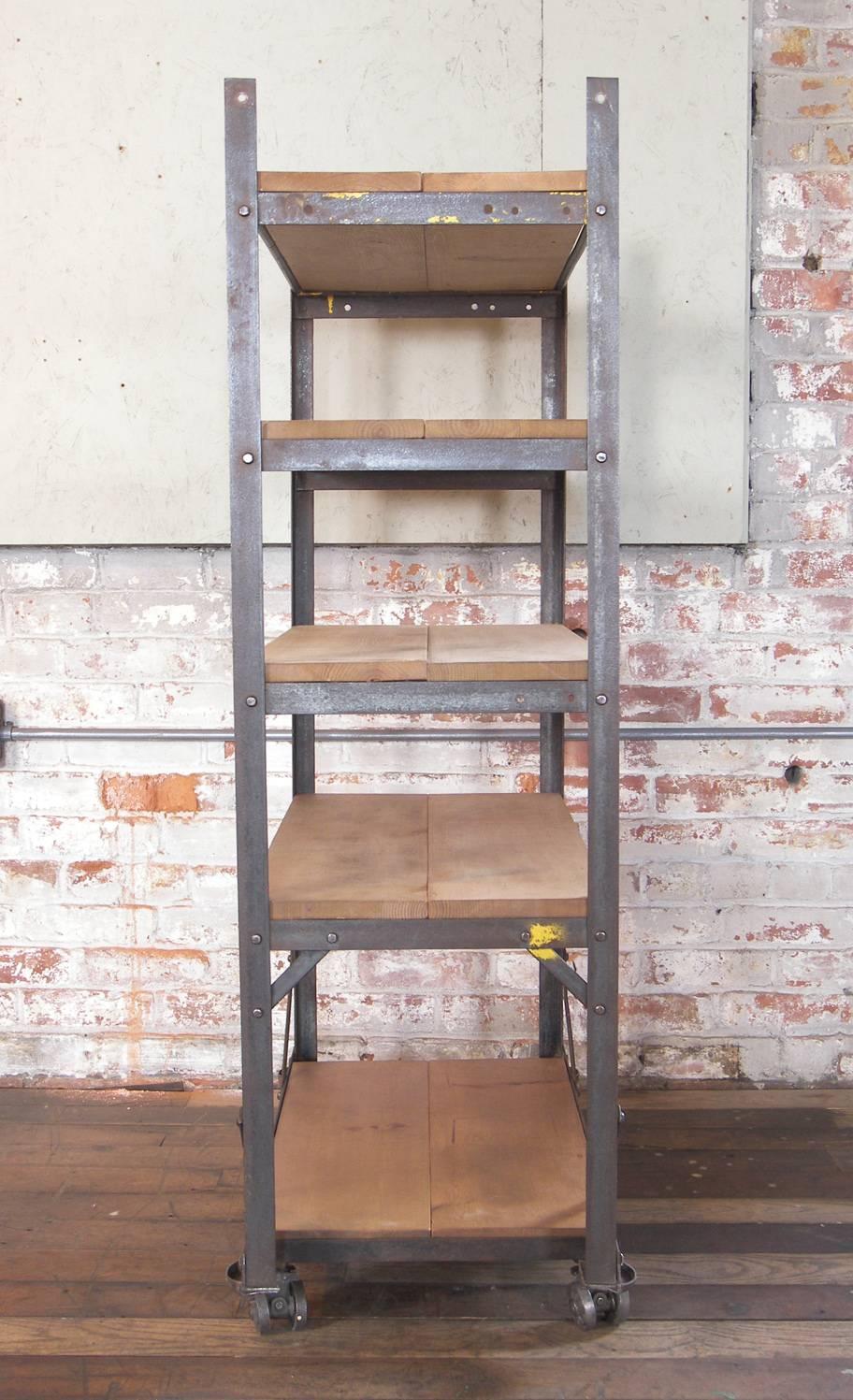 Vintage Industrial five-tier wood and metal shelving rolling bar cart / storage unit. Overall dimensions are 29 1/4″ x 16 3/4″ x 51 1/2″. Top depth is 15 1/4″. Bottom depth is 16 3/4″. Shelves measure 28 3/4″ x 13 3/4″. Shelf heights are 5″, 19