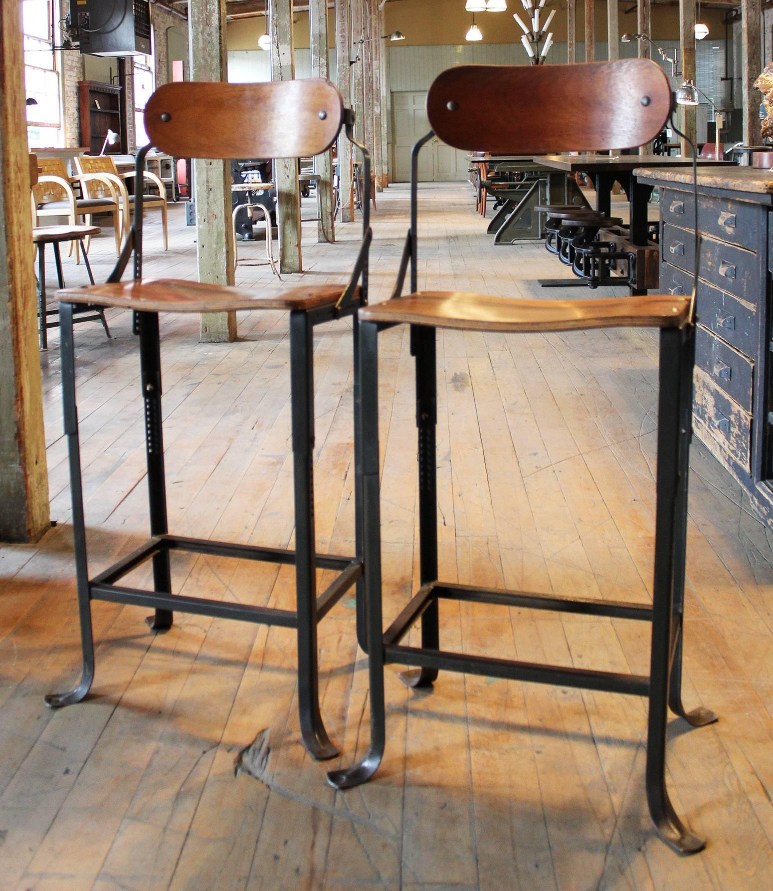 Pair of vintage Industrial DoMore metal and wood adjustable bar, counter, kitchen island stools. Bent plywood seat and backs, metal frames that adjust the height and chair back. Seat height is adjustable from 20 3/4" to 25 1/4". Seat