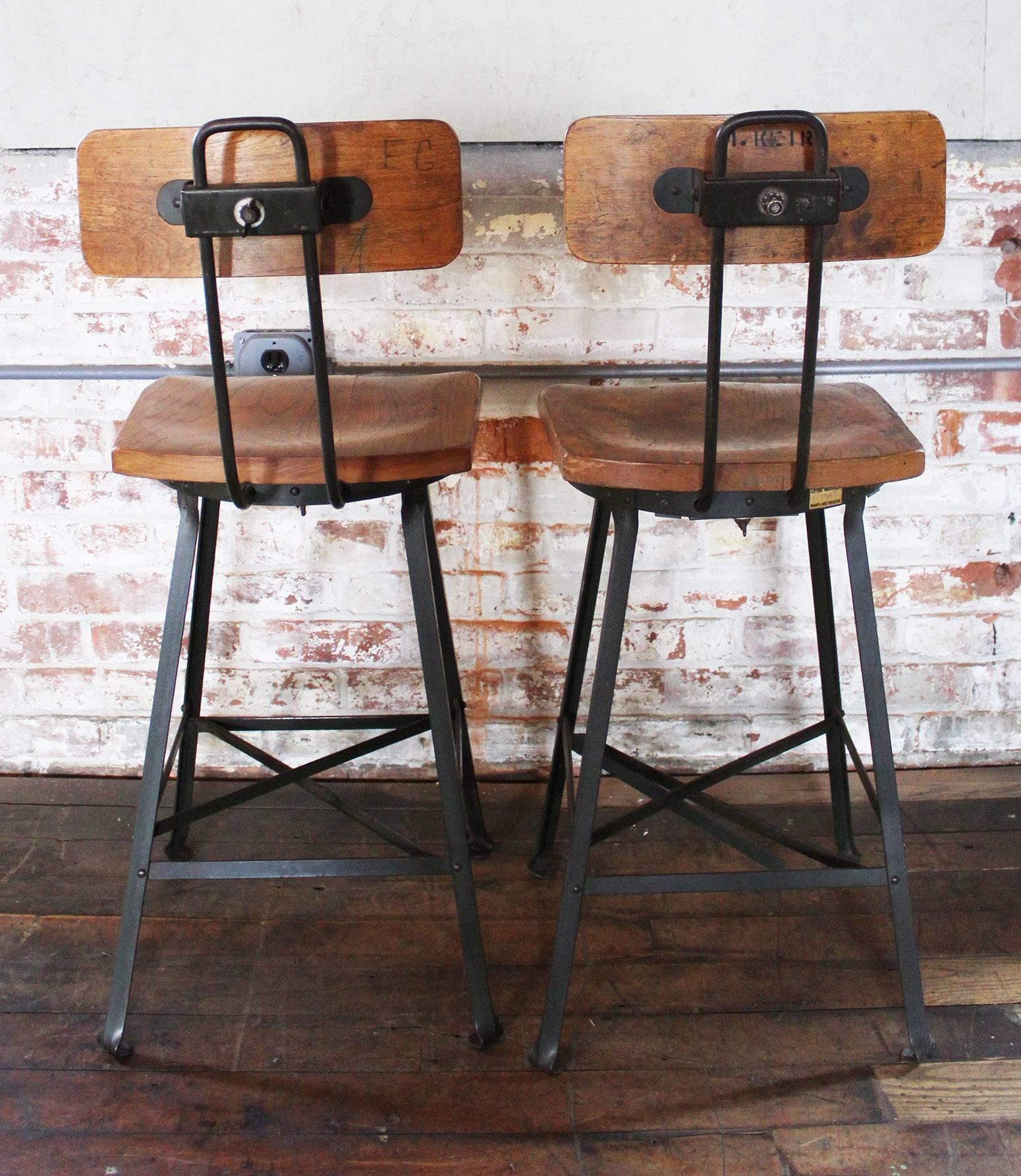 Pair of vintage Industrial wood and metal bar stools. Adjustable seat back height and depth. Overall dimensions are 36 1/2