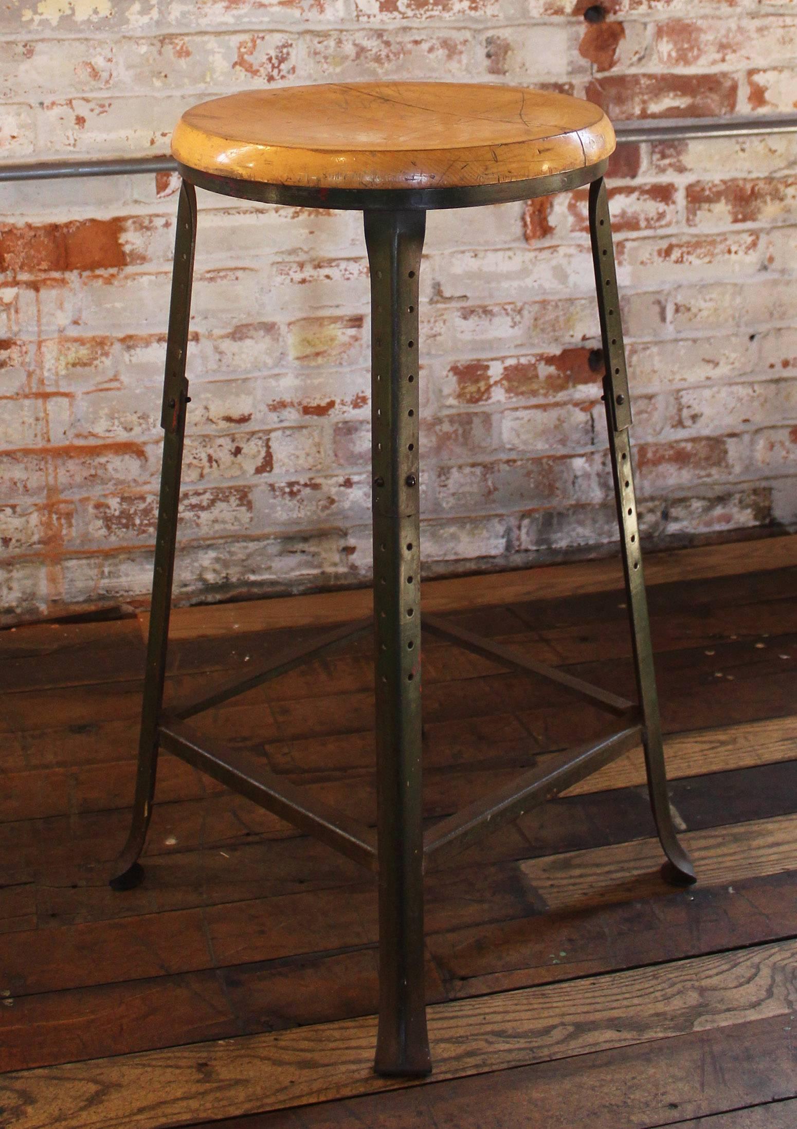 Vintage Industrial backless wood and metal bar stool. Seat diameter measures 14". Seat thickness measures 1 1/16". Measures: Height 28", depth 16", width 16".