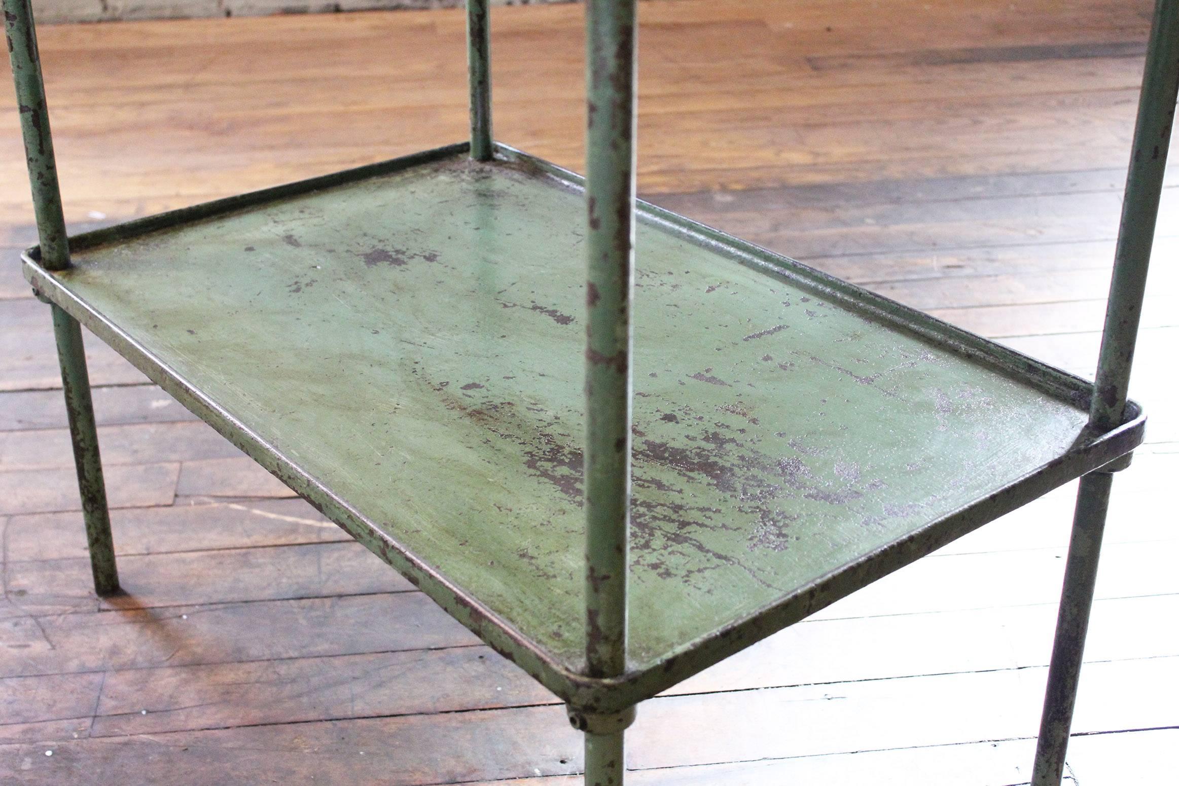 Cast iron vintage Industrial rustic steel two-tier table, bar or storage cart with adjustable shelf. Beautiful patina with worn green paint. Dimensions are 30 1/8" x 19 1/8" x 23 3/8" in Height. Shelf sits at 13".