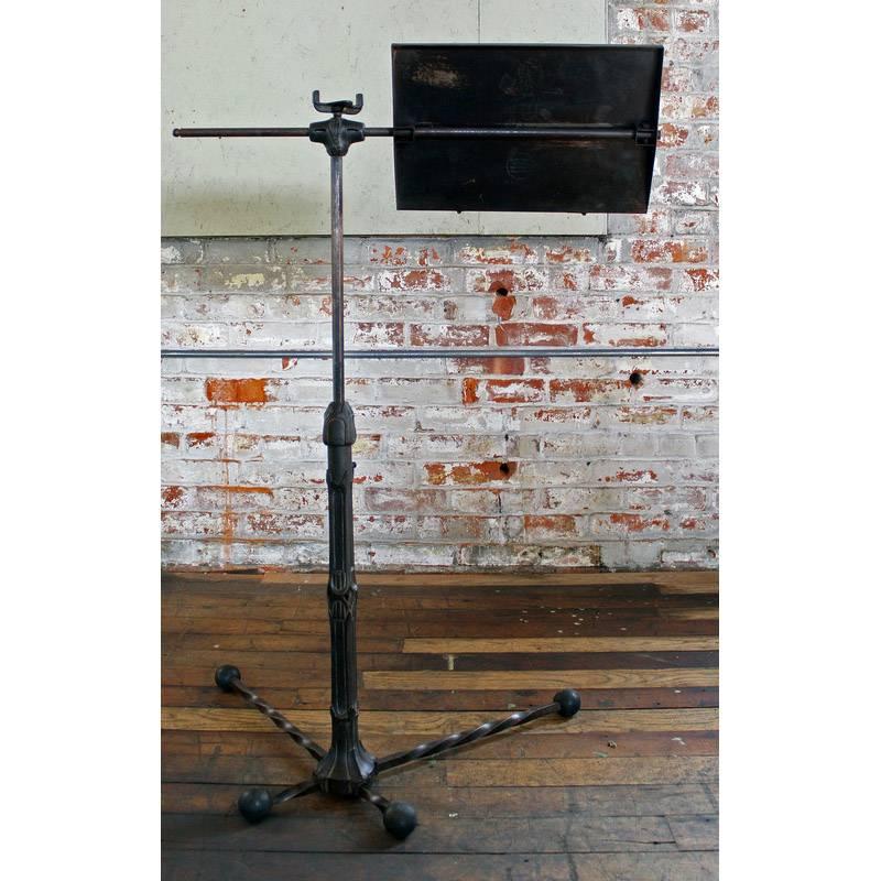 Vintage metal steel cast iron adjustable music stand. Measures 14 1/4" x 9 1/2". Height is 42". Top arm length measures 26 1/2". Base measures 26 1/4" x 19 1/4" including rubber feet. "Little Squire."