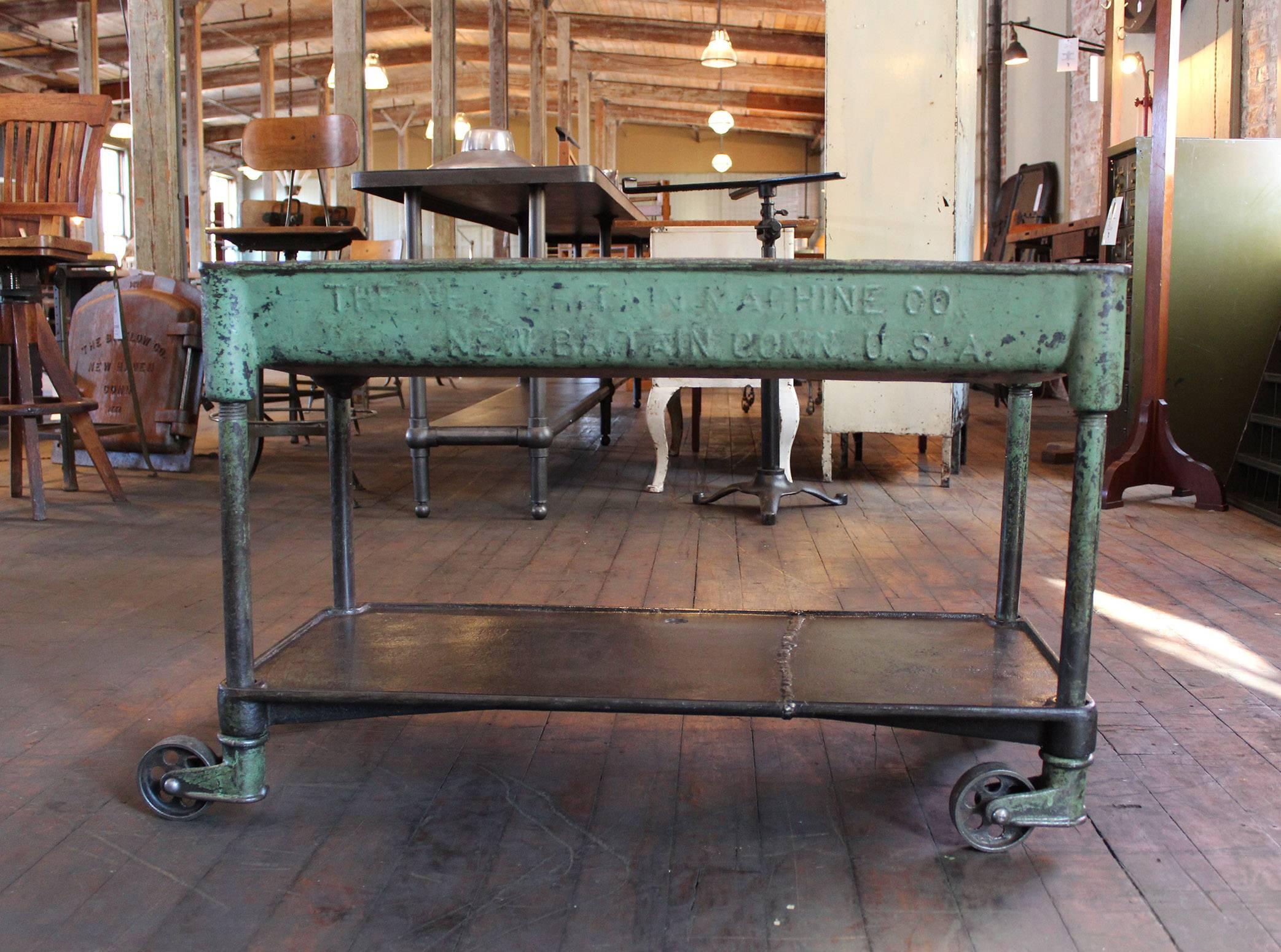 Incredible vintage Industrial cast iron machine rolling bar cart on four swivel castors. An exceptional piece. Measures: 36" x 16 1/2" 23 1/4" in height. Shelf measures: 6 1/4" from floor.