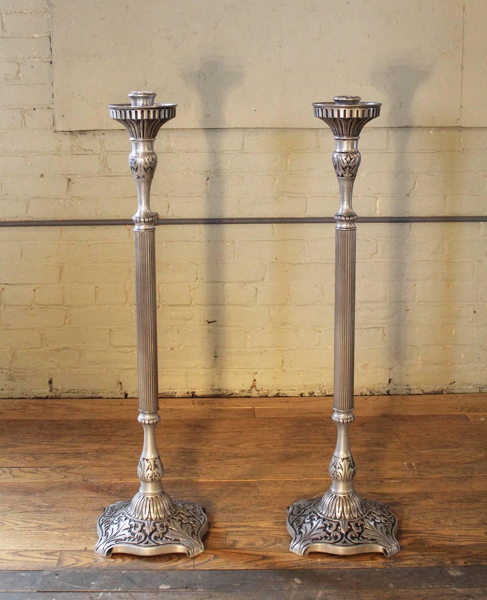 Pair of tall, floor pillar Victorian candle stands holders made from brass featuring a pewter finish. These were purchased from a traveling undertaker in upstate New York. Made out of cast alloy, from early 1900s. They stand 46" tall with